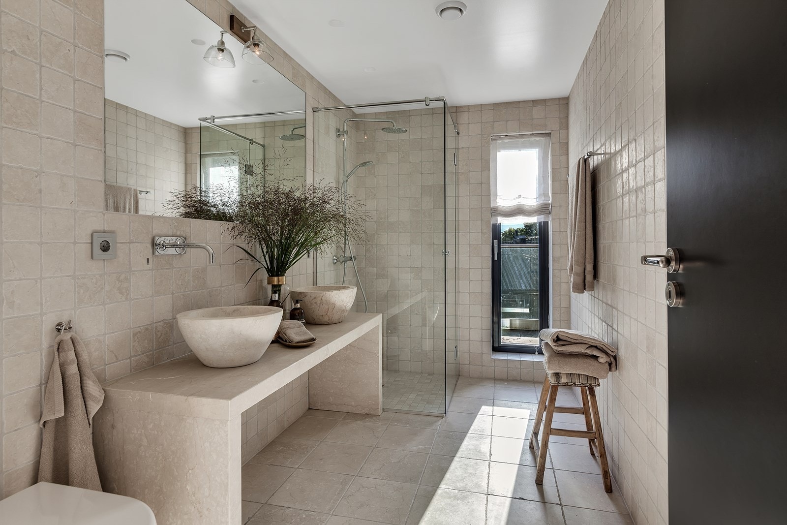 Delikat flislagt baderom med regnfallsdusj og dobbelservant. Galleribilde