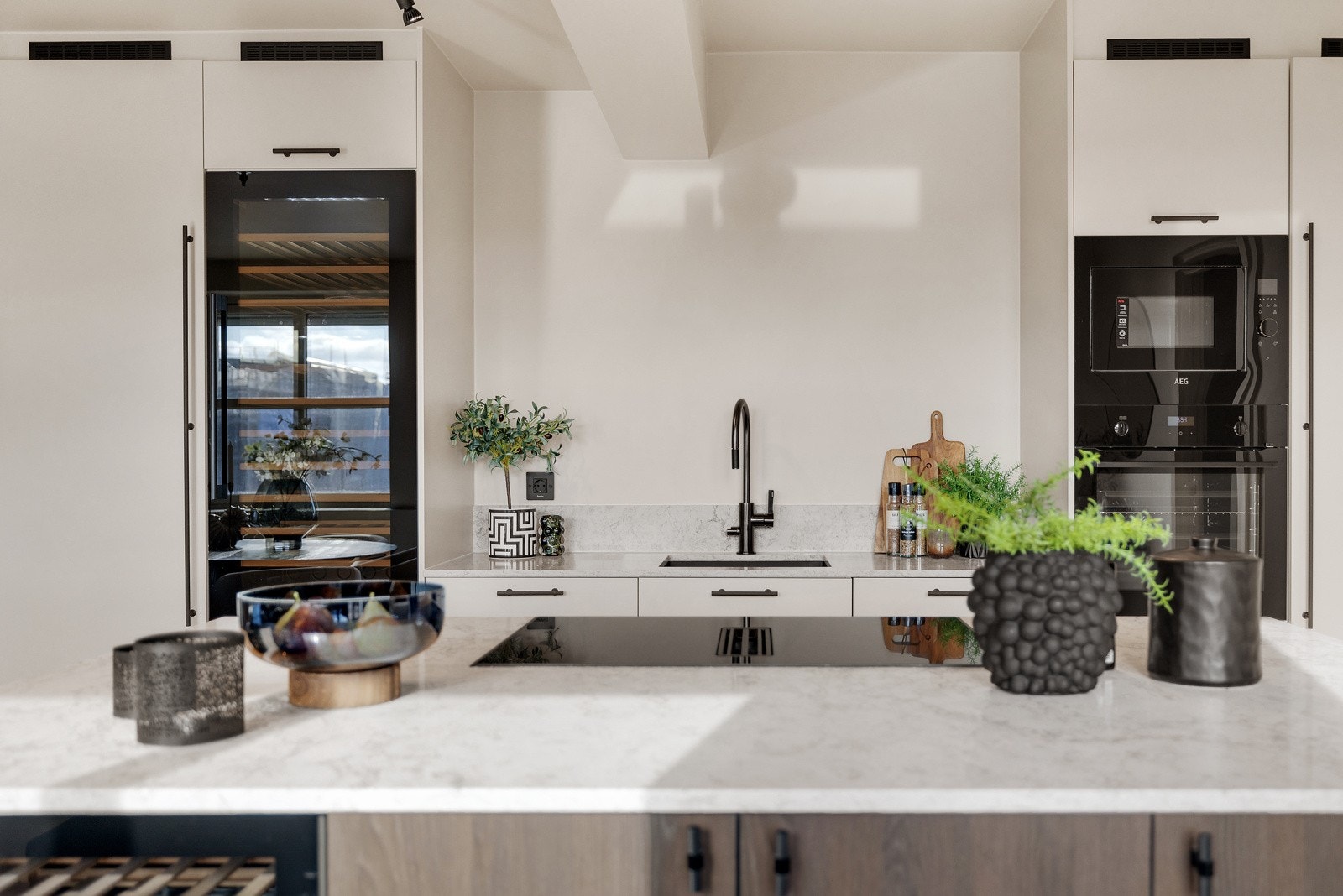 Delikat HTH kjøkkeninnredning med integrerte hvitevarer som oppvaskmaskin, stekeovn, micro, induksjonstopp, 2 vinskap og helintegrert kjøl og fryseskap Galleribilde