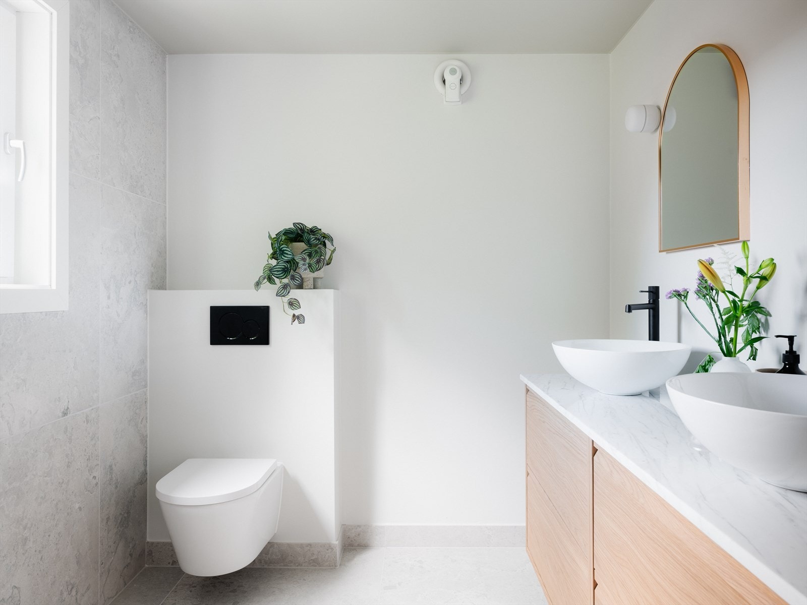 Marmorplate med dobbelservant, veggmontert toalett og god lagringsplass i underskap Galleribilde