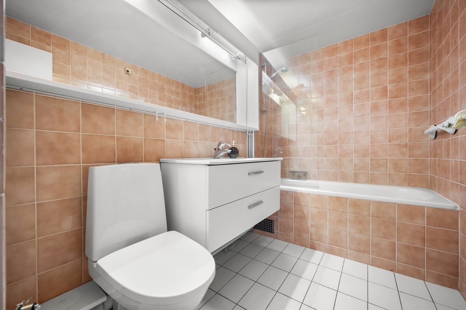 Pent flislagt bad med badekar og varmekabler i gulv. Galleribilde