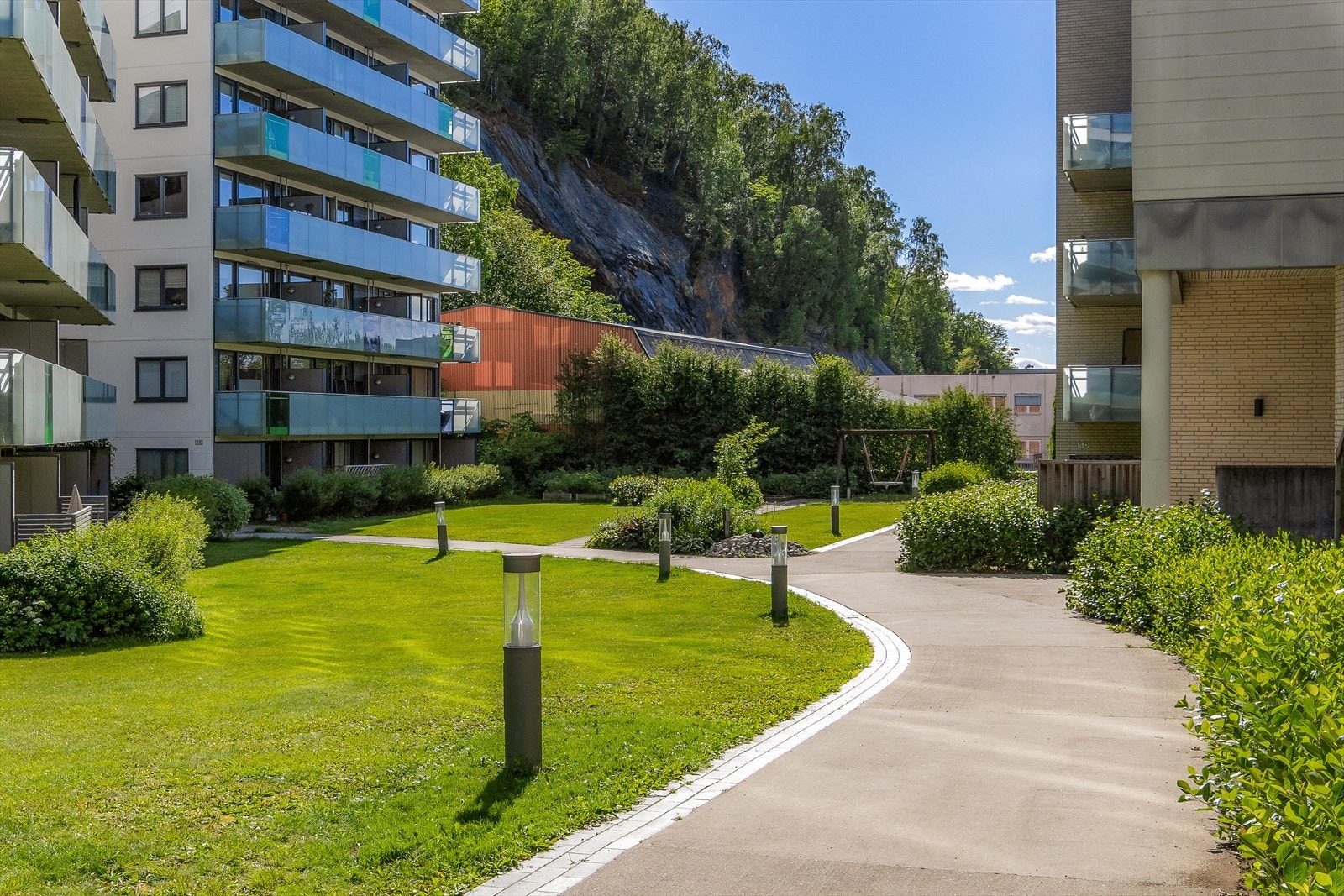 Hyggelig fellesområde mellom blokkene med opplyst sti inn til bygget Galleribilde