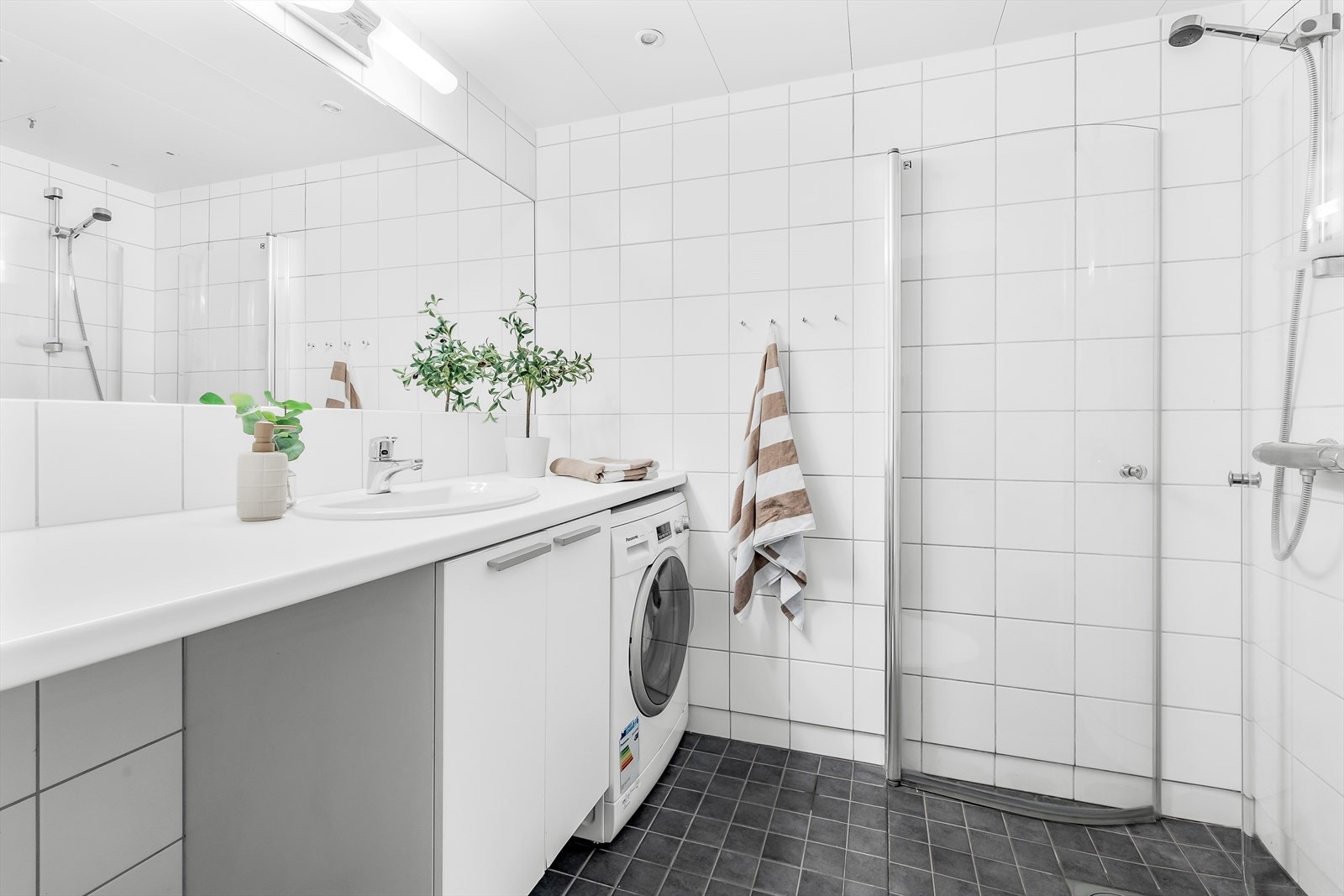 Flislagt og tidløst bad fra byggeår med opplegg for vaskemaskin og tørketrommel, samt varmekabler i gulvet. Galleribilde