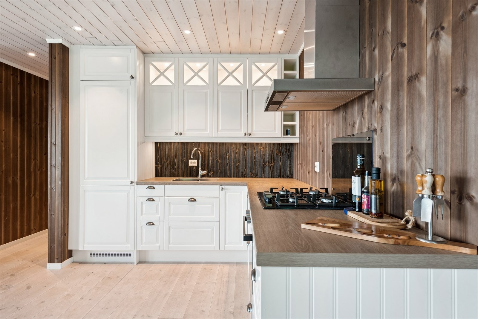 Flott kjøkken med rikelig skap- og benkleplass. Kjøkkenventilator er montert over komfyr. Galleribilde