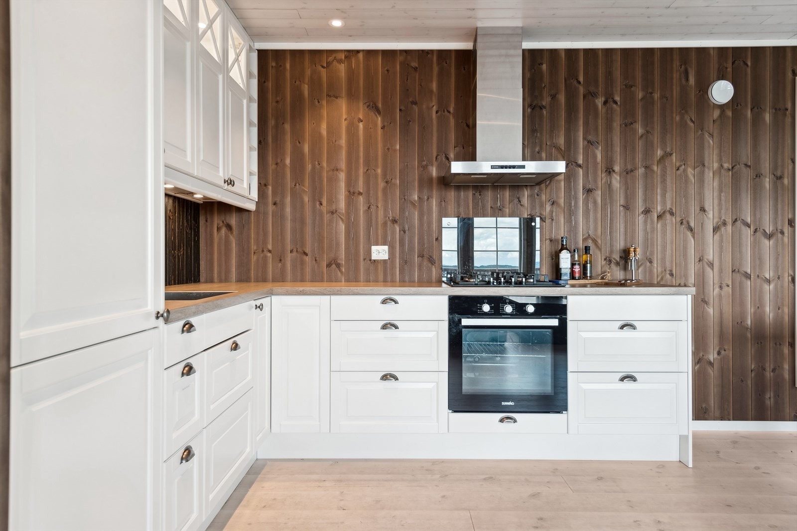 Kjøkkeninnredning med laminerte skrog, profilerte fronter og laminert benkeplate med kjøkkenkum. Galleribilde