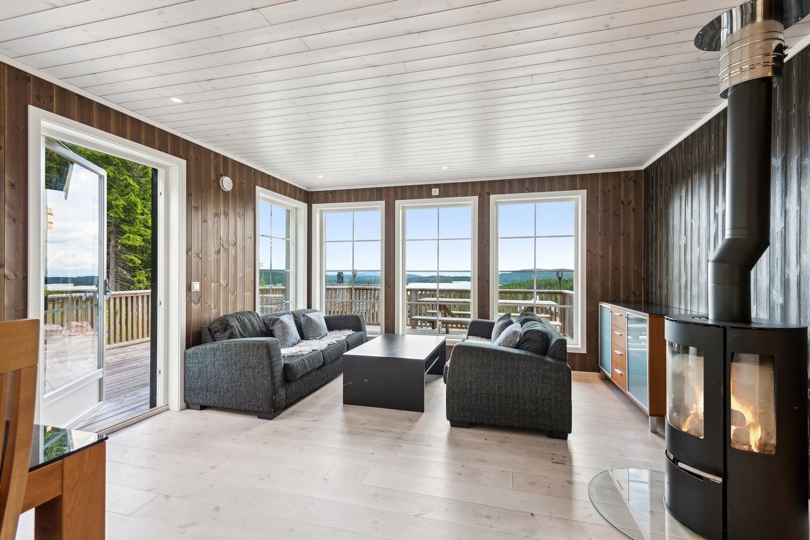 Lys og trivelkig stue med store vindusflater som gir mye naturlig lysinnslipp og bidrar til en behagelig romfølelse. Galleribilde