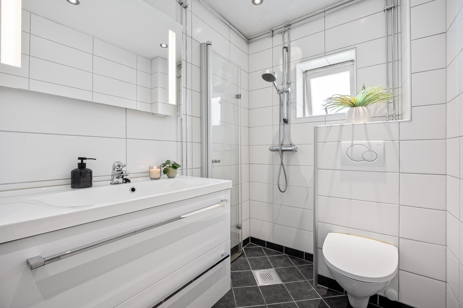 Badet er heltfliset med tidløse fargevalg og moderne baderomsinnredning. Galleribilde