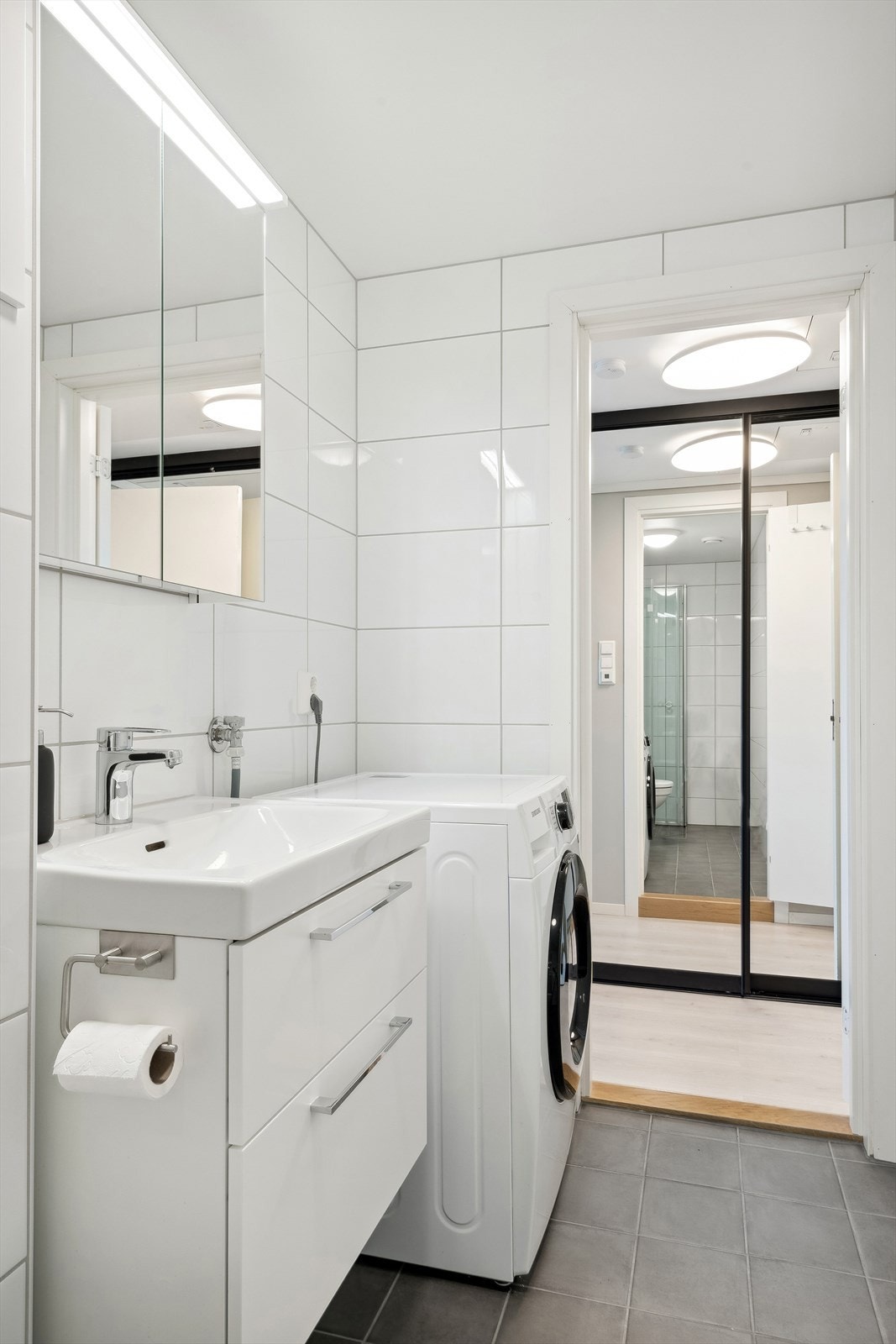 Badet inneholder toalett, dusj med vegger og servant med skapinnredning. Opplegg for vaskemaskin. Galleribilde