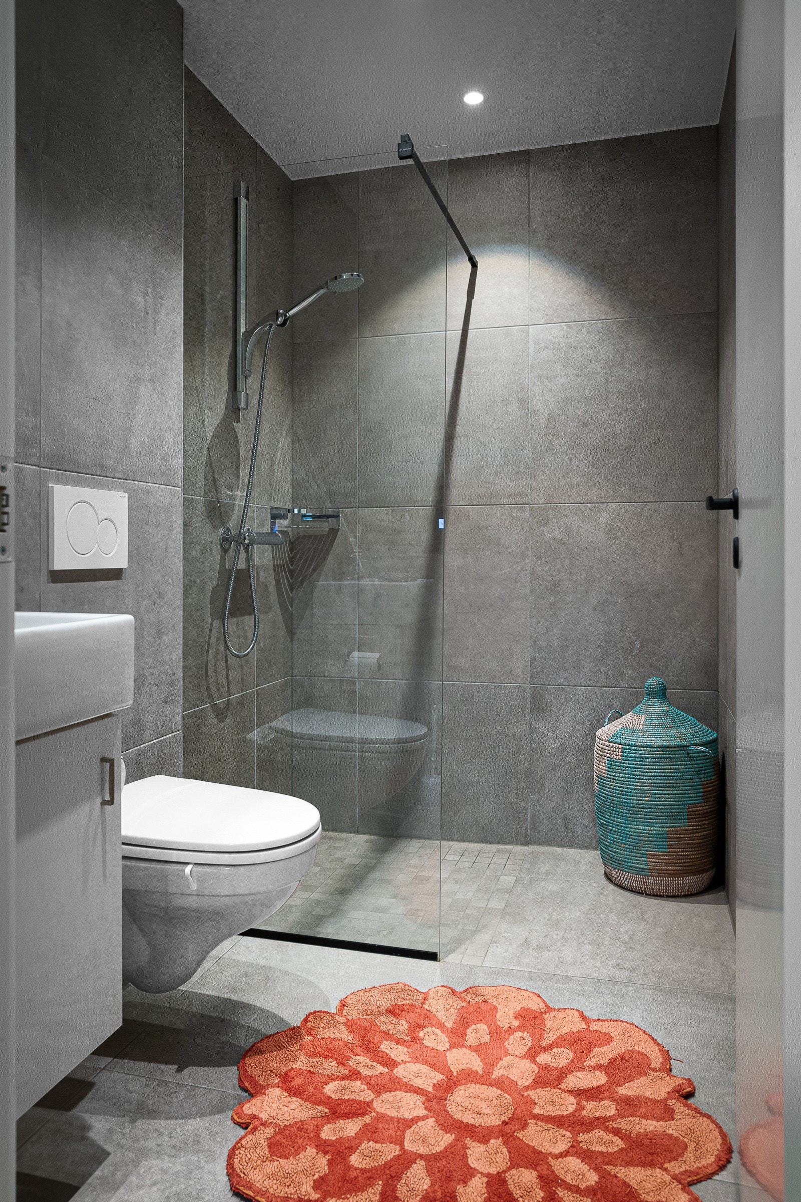 Adkomst fra gang til pent bad fra 2020 med store delikate fliser på gulv og vegger. Galleribilde