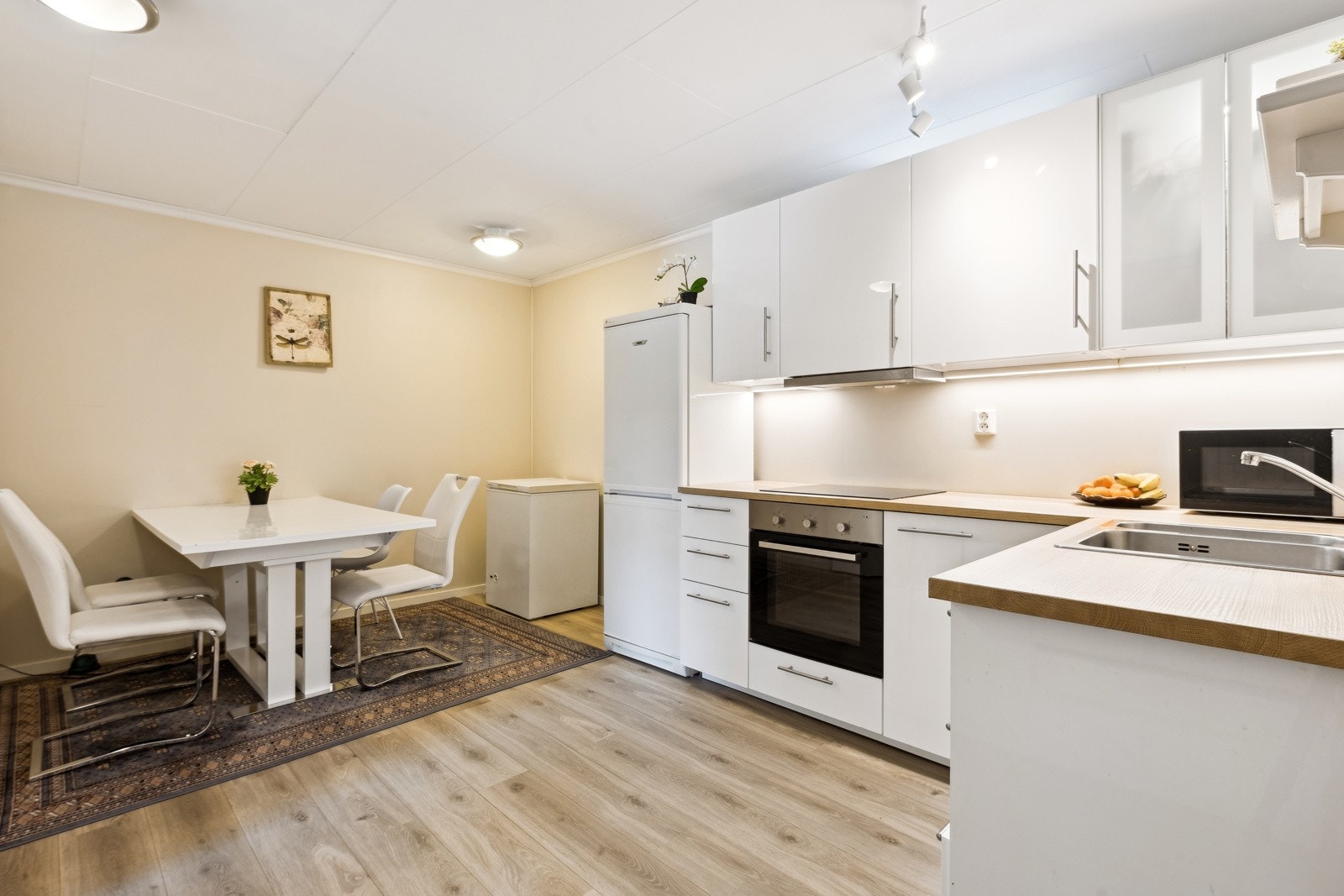 Åpen kjøkkenløsning som skaper naturlig plass til en spisegruppe. Galleribilde