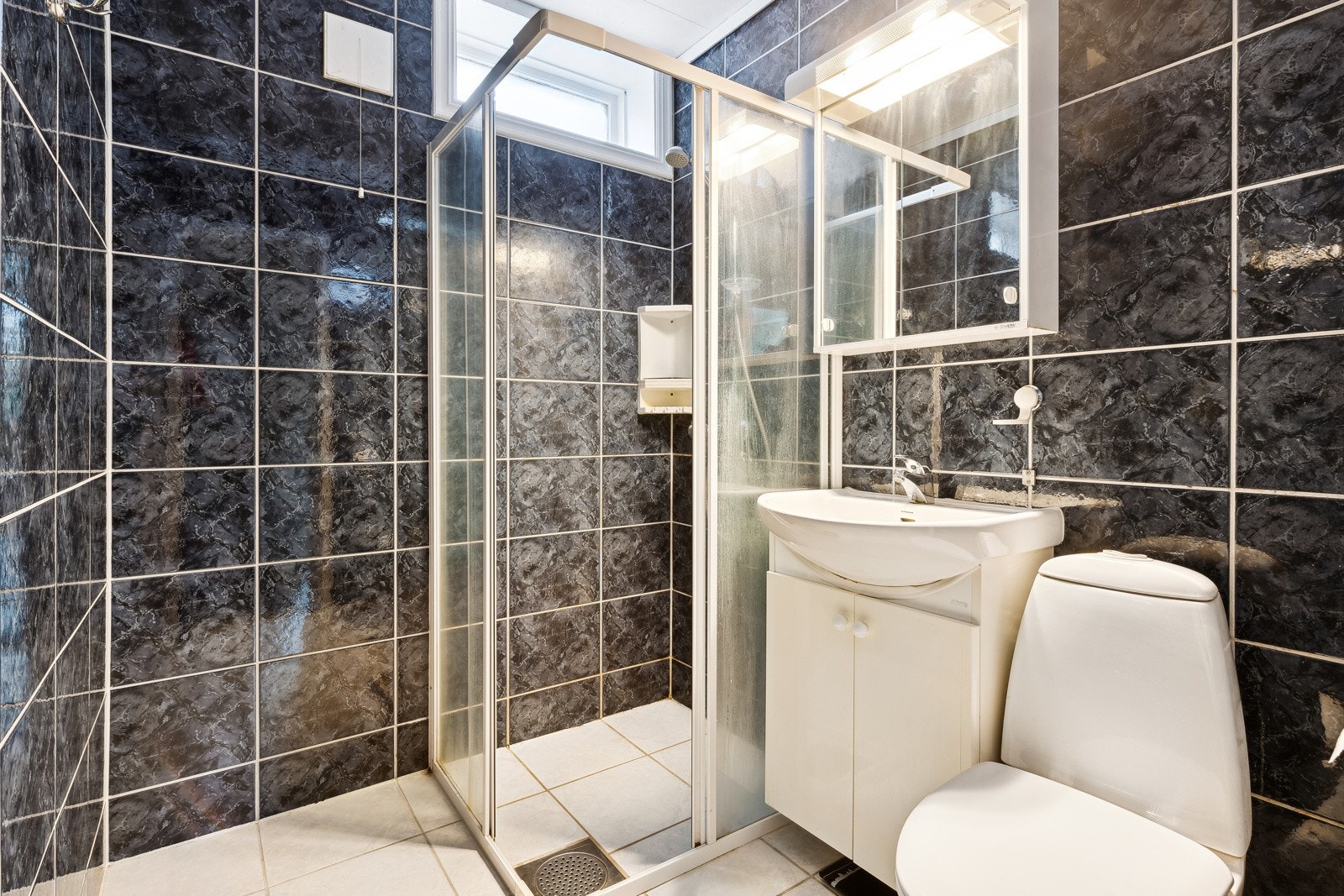 Badet er utstyrt med dusjnisje med glassvegg og glassdør. Galleribilde