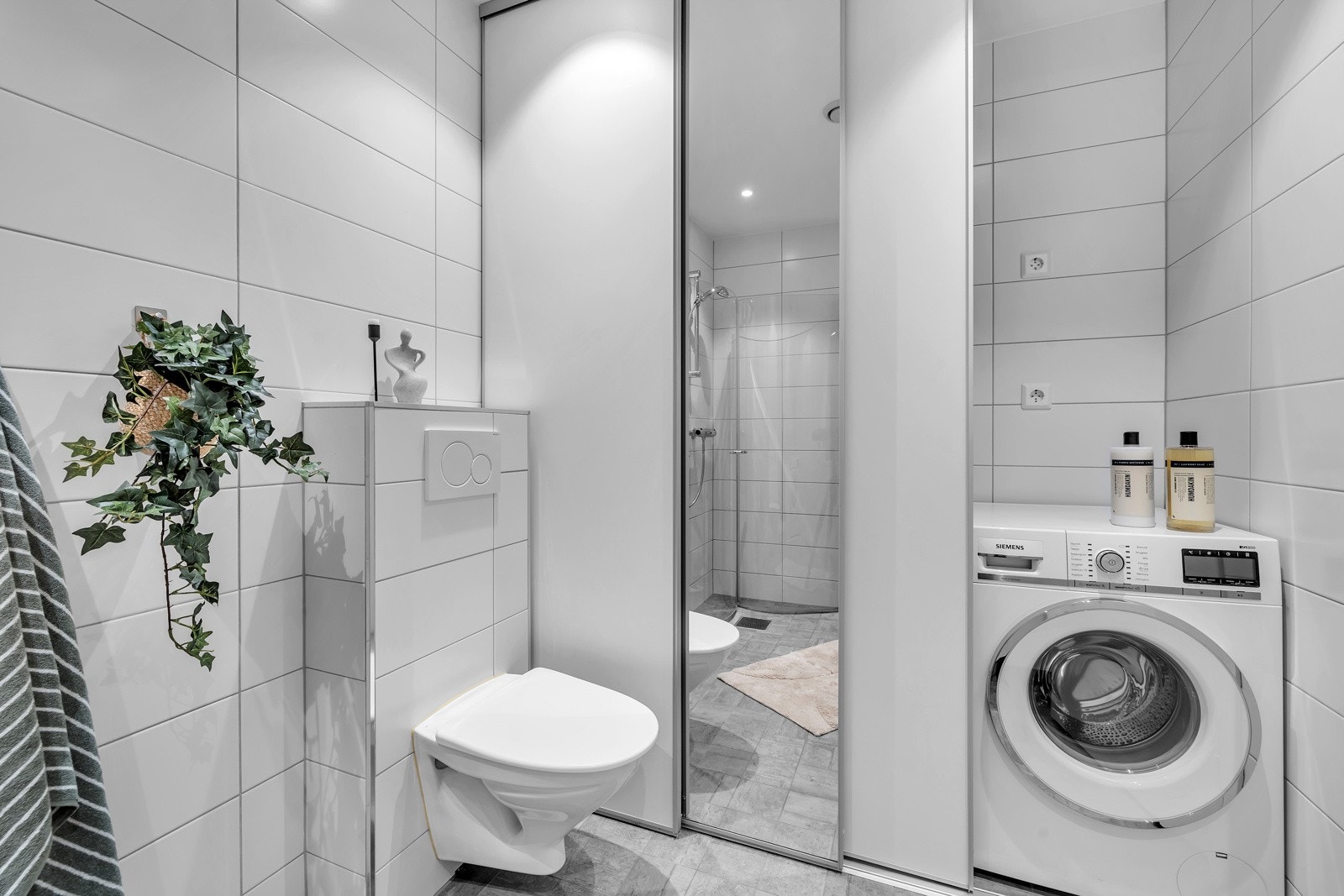 Praktisk løsning hvor hvitevarer er "gjemt" i skyvedørsgarderobe Galleribilde