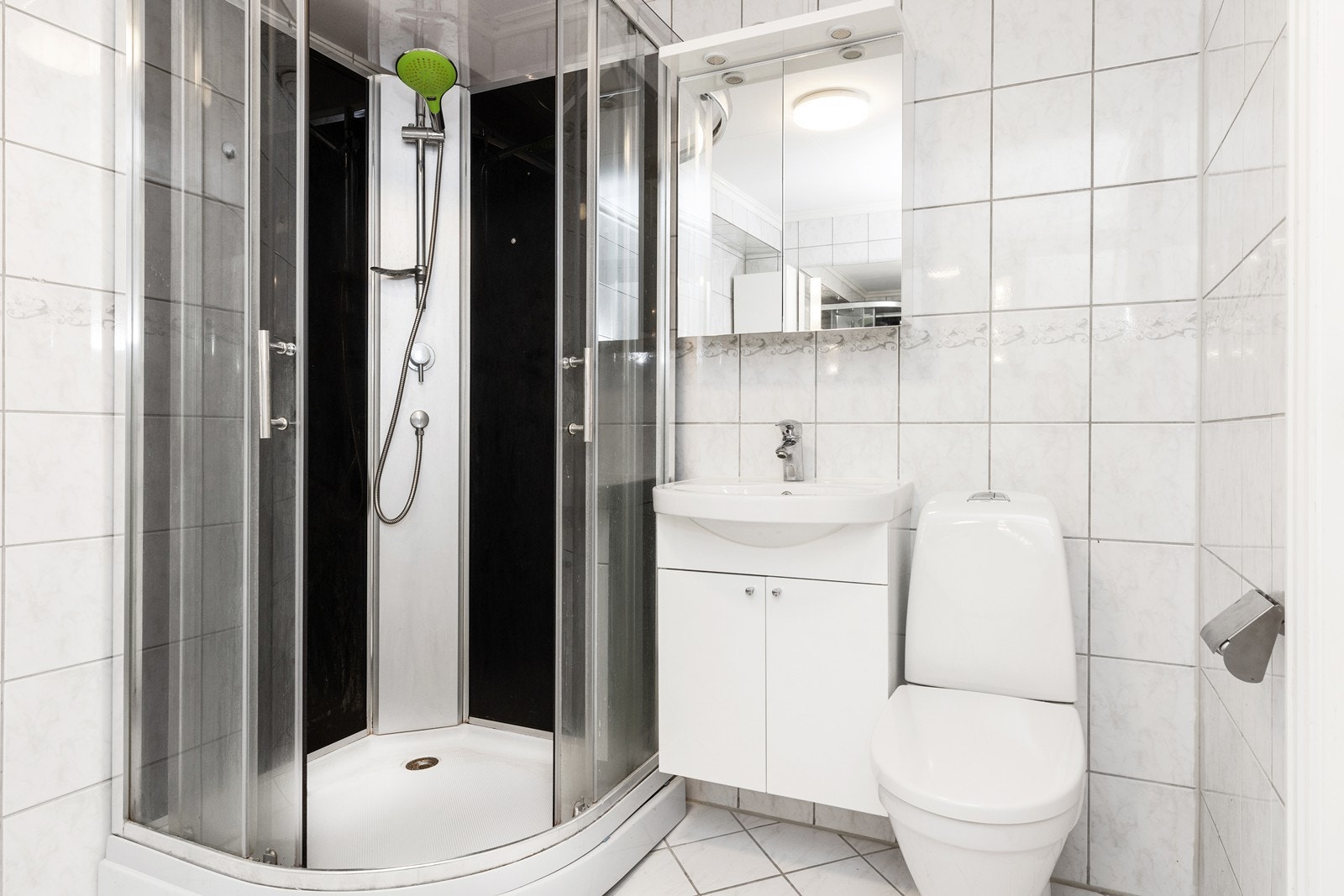 Flislagt bad med dusjkabinett, servantinnredning og wc. Galleribilde