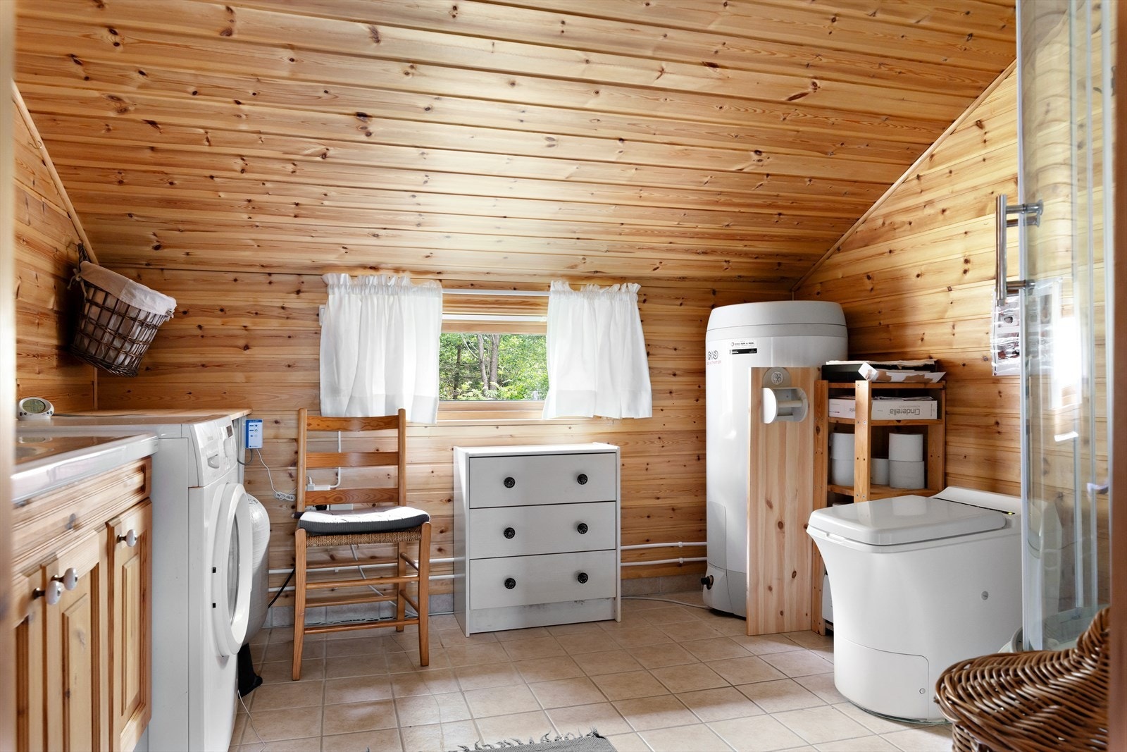 Romslig bad/vaskerom har innredning med nedfelt servant i benkeskap, veggskap og speil, forbrennings toalett, dusjkabinett og opplegg for vaskemaskin. Galleribilde