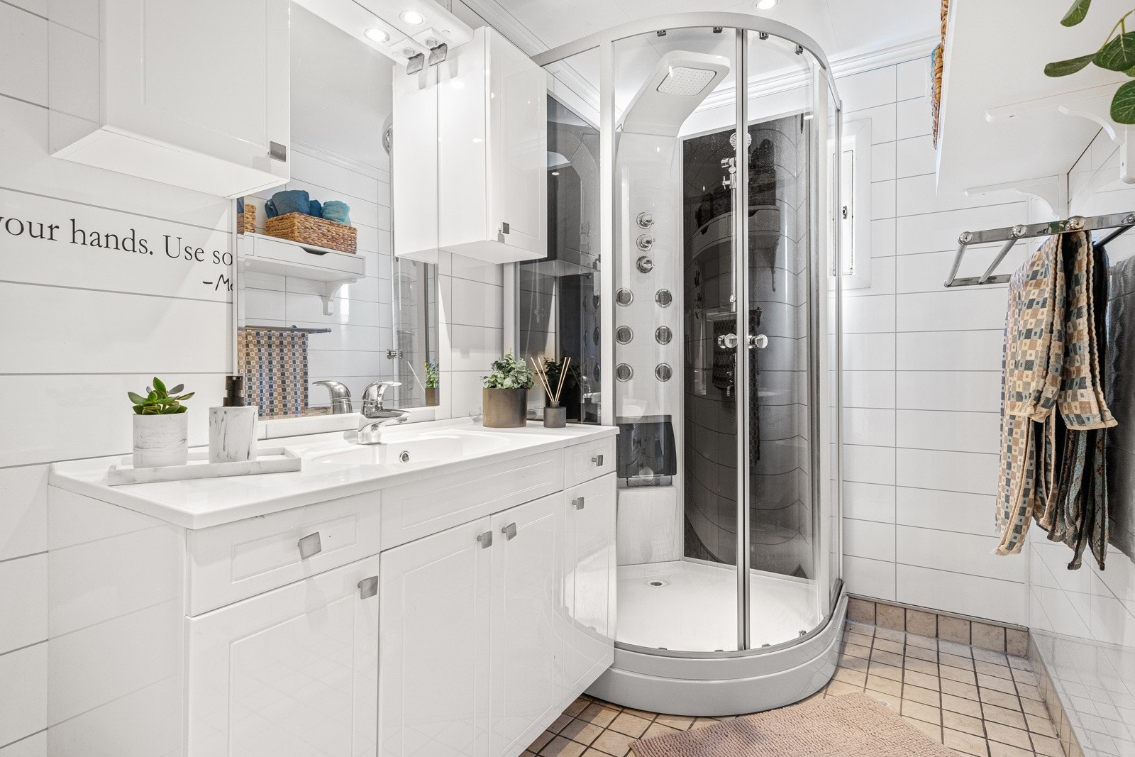 Badet er utstyrt med dusjkabinett, toalett, vegghengt servantinnredning og skap. Galleribilde