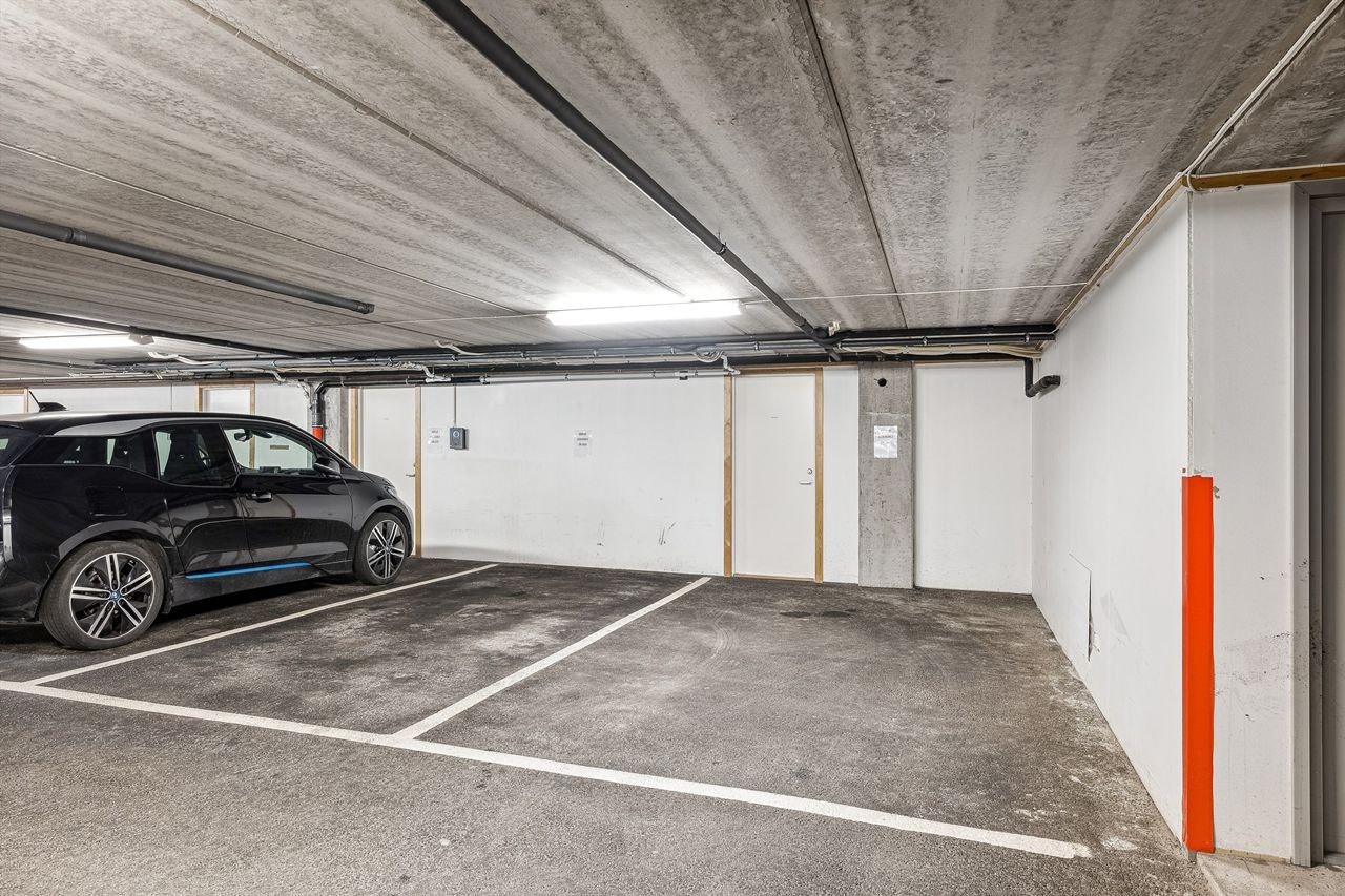 Garasjeplass i garasjekjeller med bod i bakkant. Galleribilde