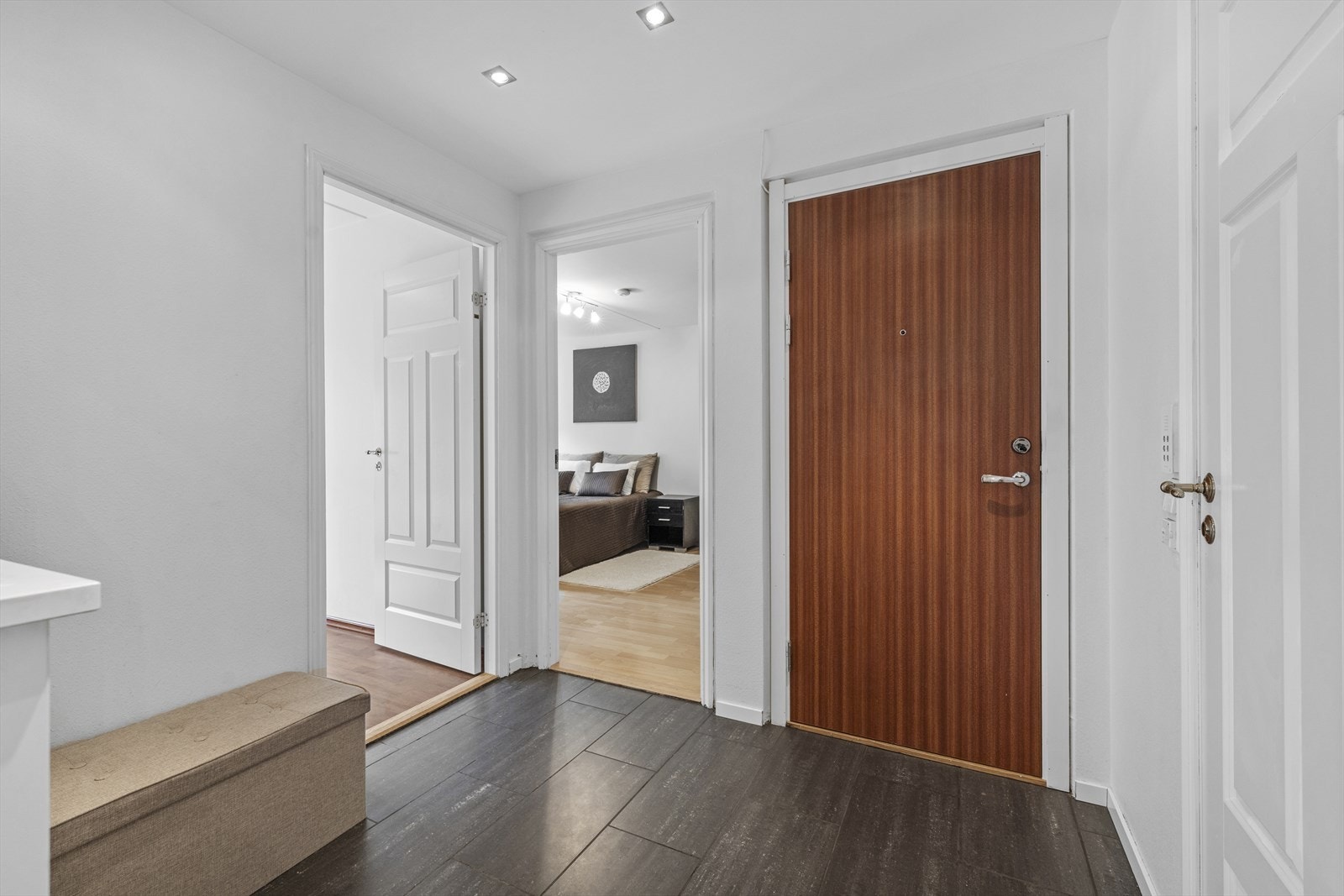 Innbydende og romslig entré med lyse vegger og downlights i tak. Entréen gir et godt førsteinntrykk av leiligheten og har god plass til oppbevaring og oppheng av yttertøy og sko Galleribilde
