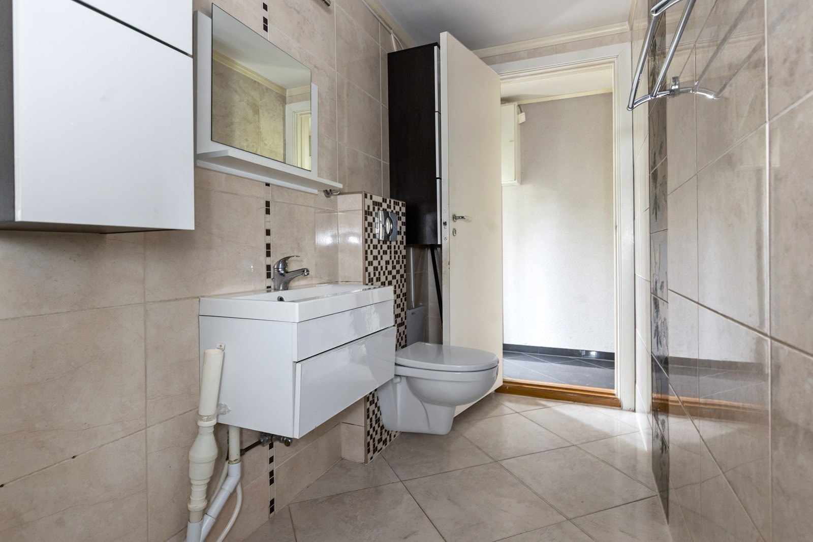 Det er servant med skuff over og speil på vegg. Galleribilde