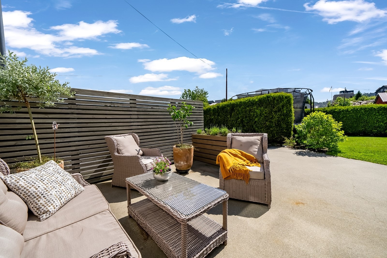 På fremsiden av boligen går en støpt terrasse rett over i gresslagte områder med rom for lek og moro for store og små. Galleribilde