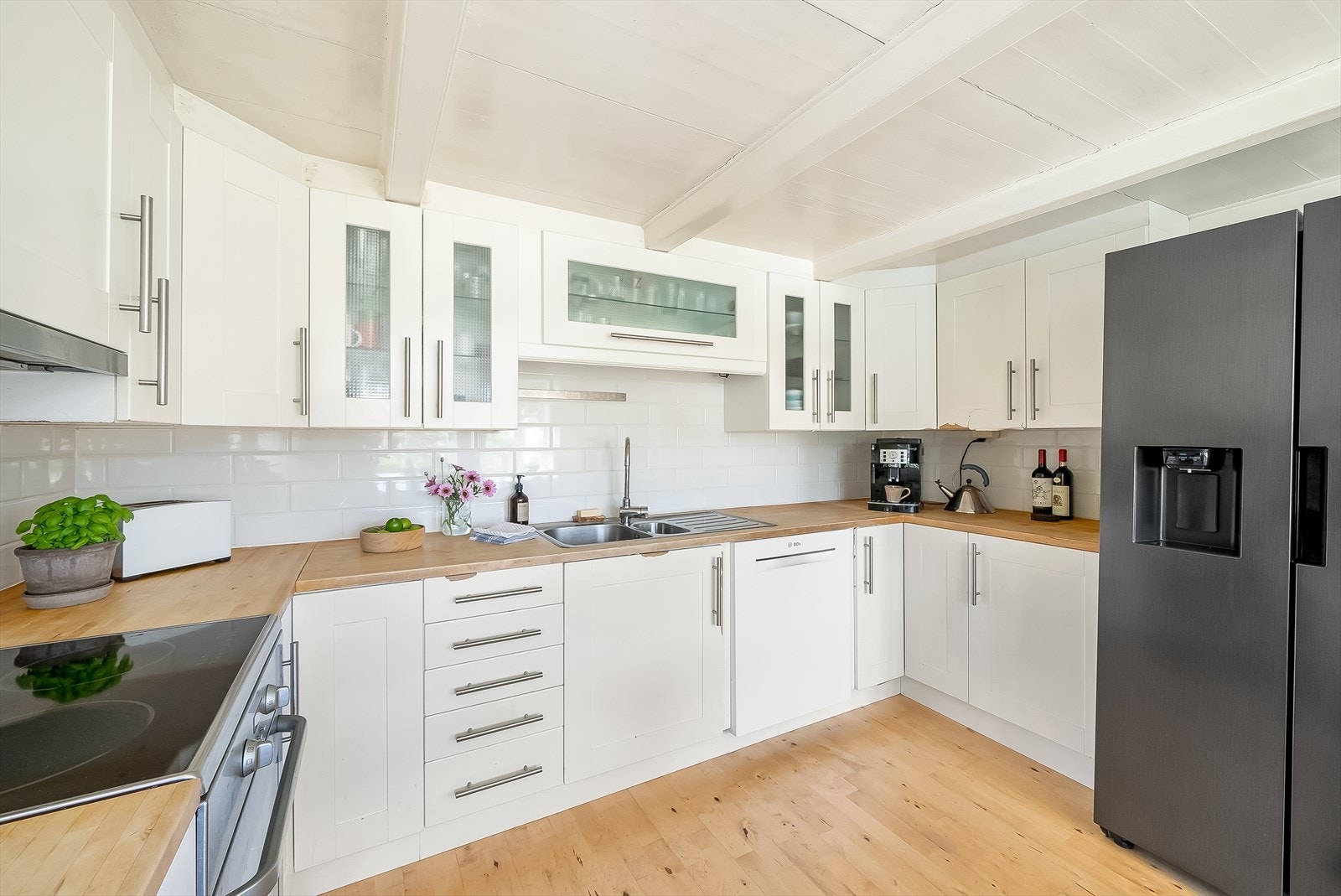 Kjøkkenet har heltre benkeplate og fliselagt mellom skapene. Galleribilde