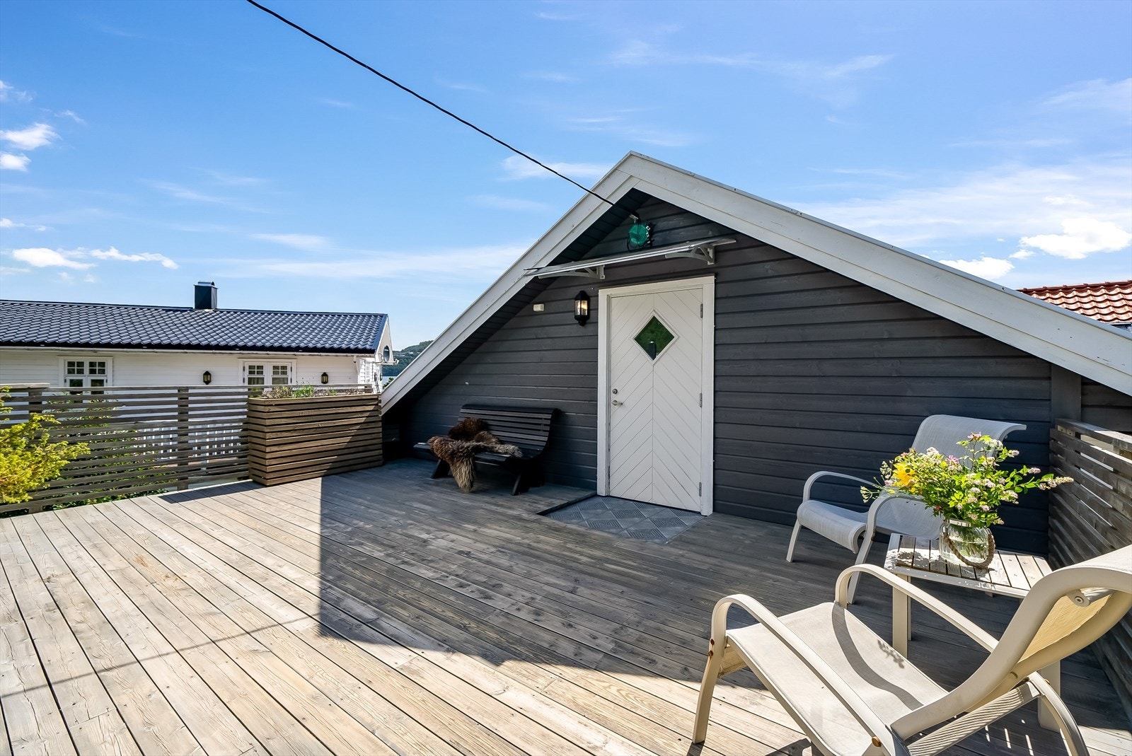 Stor solrik terrasse med inngang til loftet på garasjen. Galleribilde