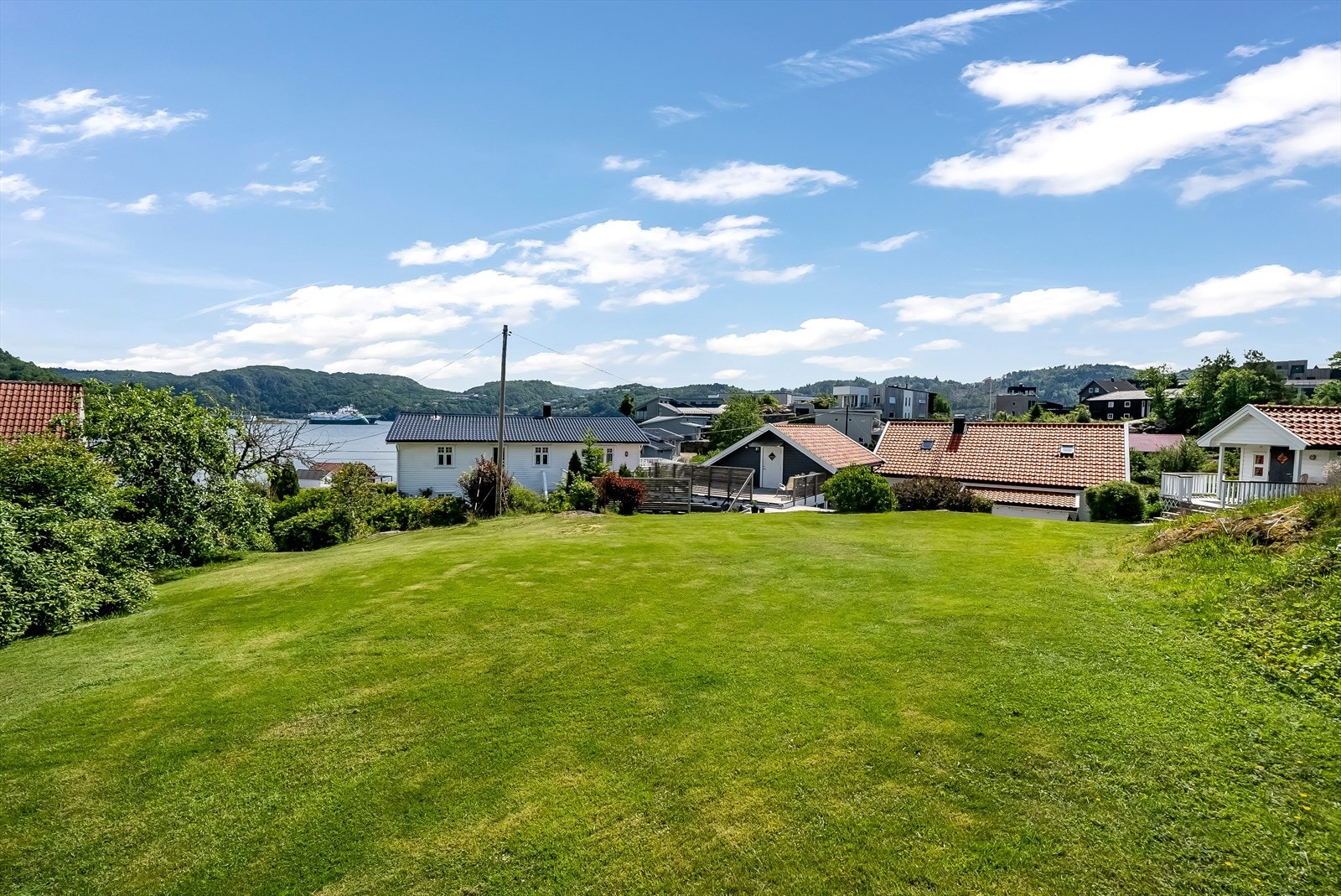 I bakre del av tomta grenses det mot et friareal som flere eiendommer benytter seg av. Her går det en robotklipper som naboene har spleiset på. Galleribilde