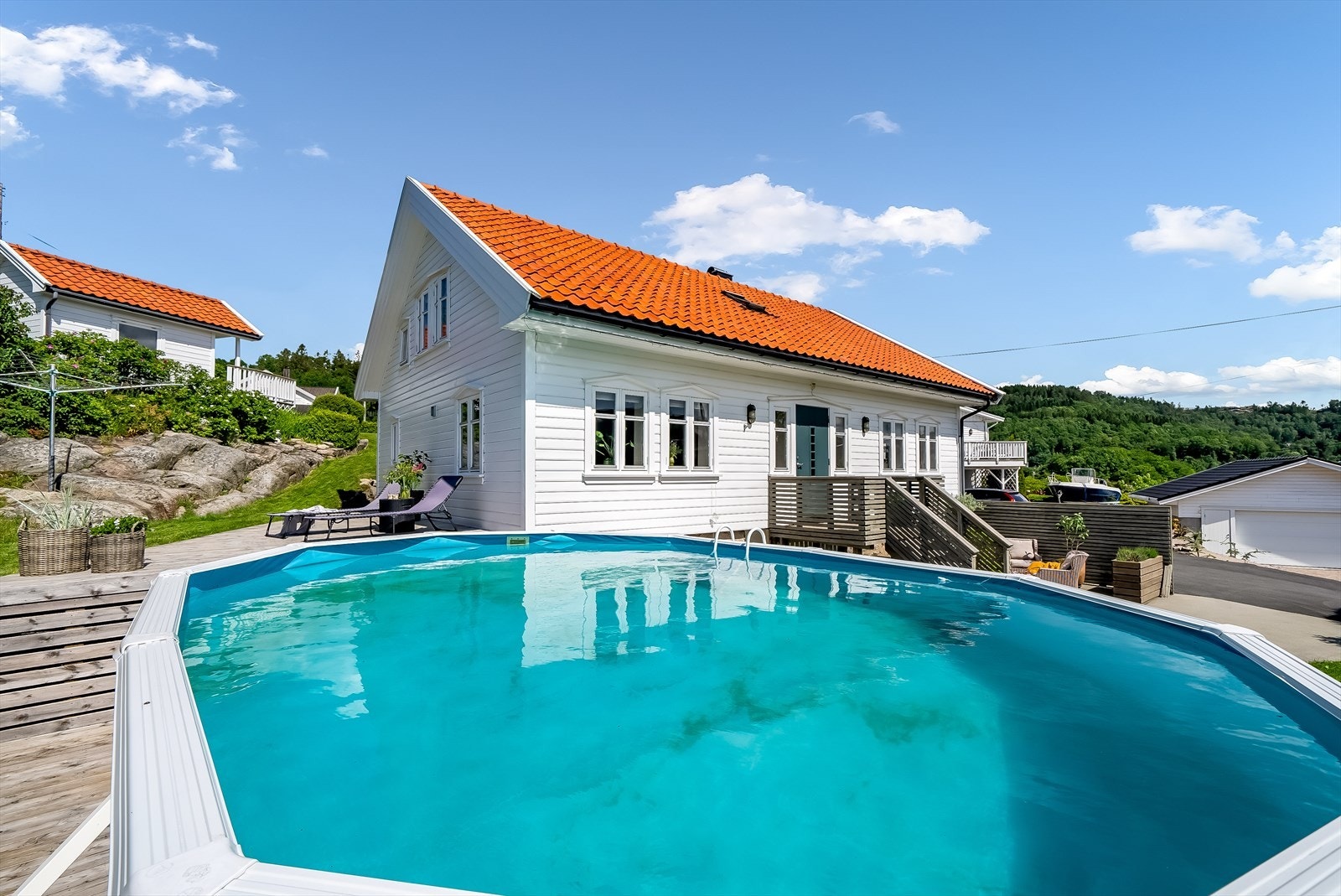 I hagen står det et stort badebasseng, som medfølger handelen. Badebassenget står på bakkeplan. Galleribilde