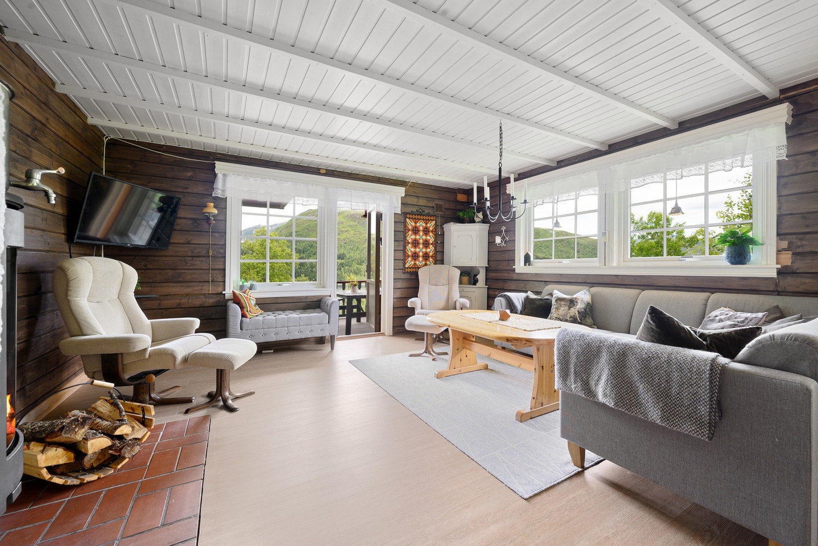 Flere vindusflater som gir godt dagslys inn i stuen Galleribilde