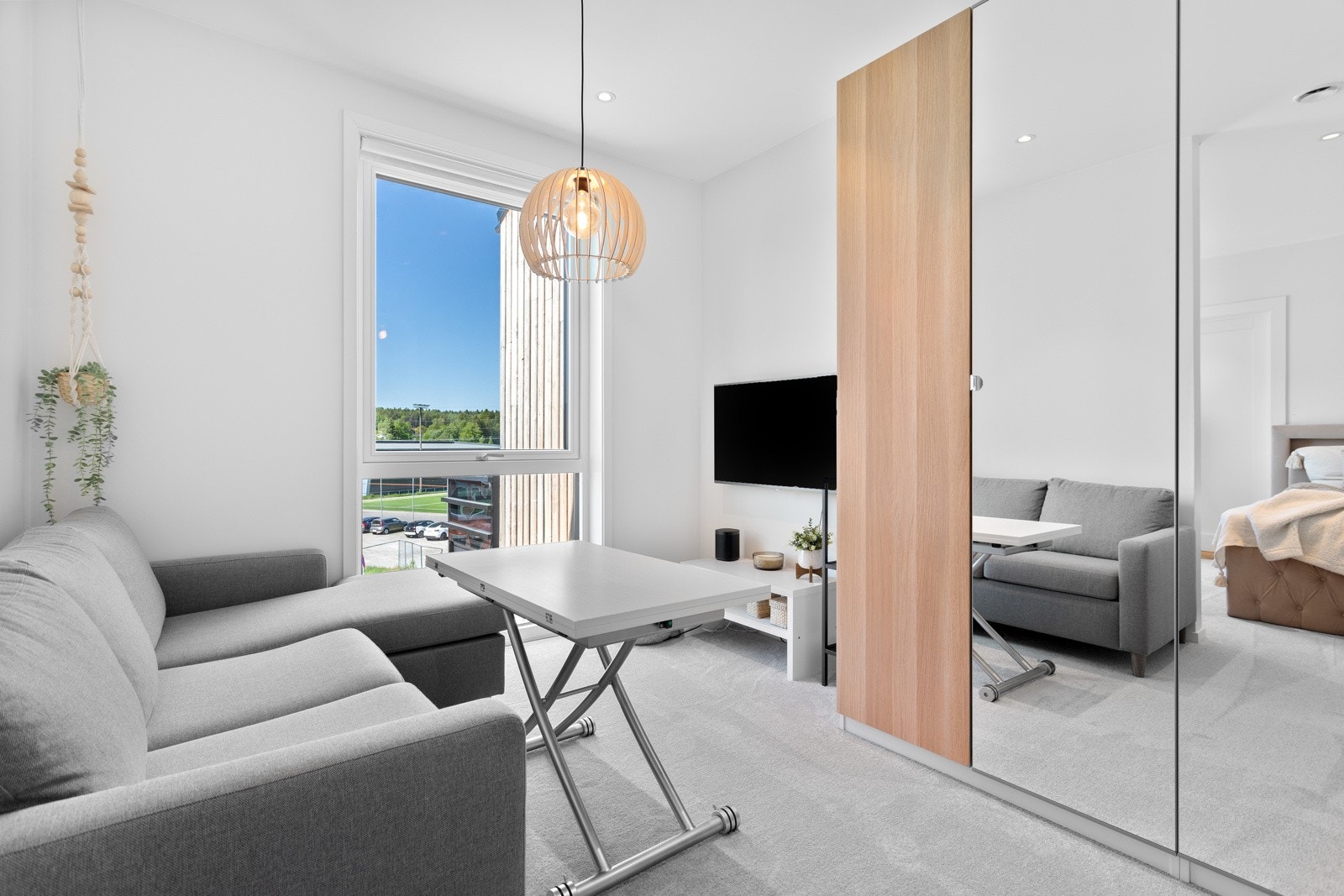 Lyst og lekkert rom med plass for både dobbel seng, sofagruppe, arbeidsplass og garderobeløsning. Galleribilde