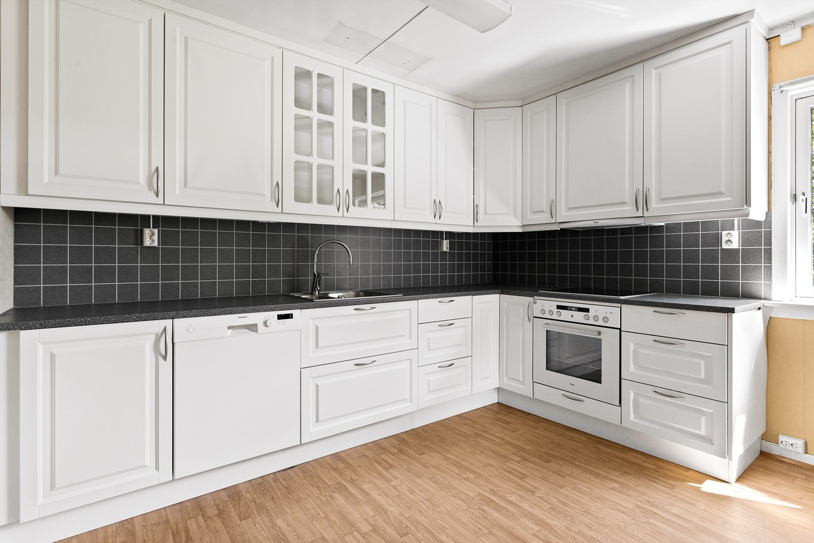 Det er integrert koketopp og komfyr, og det er plass til frittstående oppvaskmaskin og kjøle-/fryseskap. Det er mekanisk avtrekk med uttak til vegg over kokeplass. Galleribilde