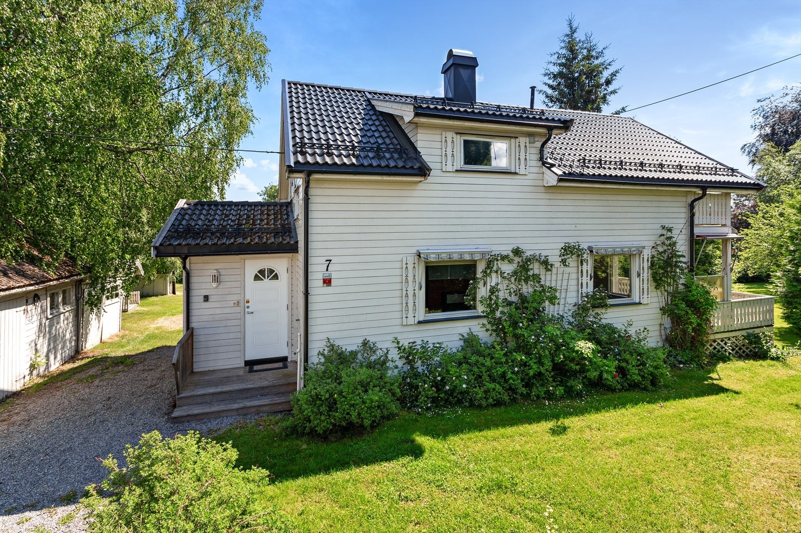 Tomten er flat og skrånende og opparbeidet med plen og variert beplantning. Galleribilde