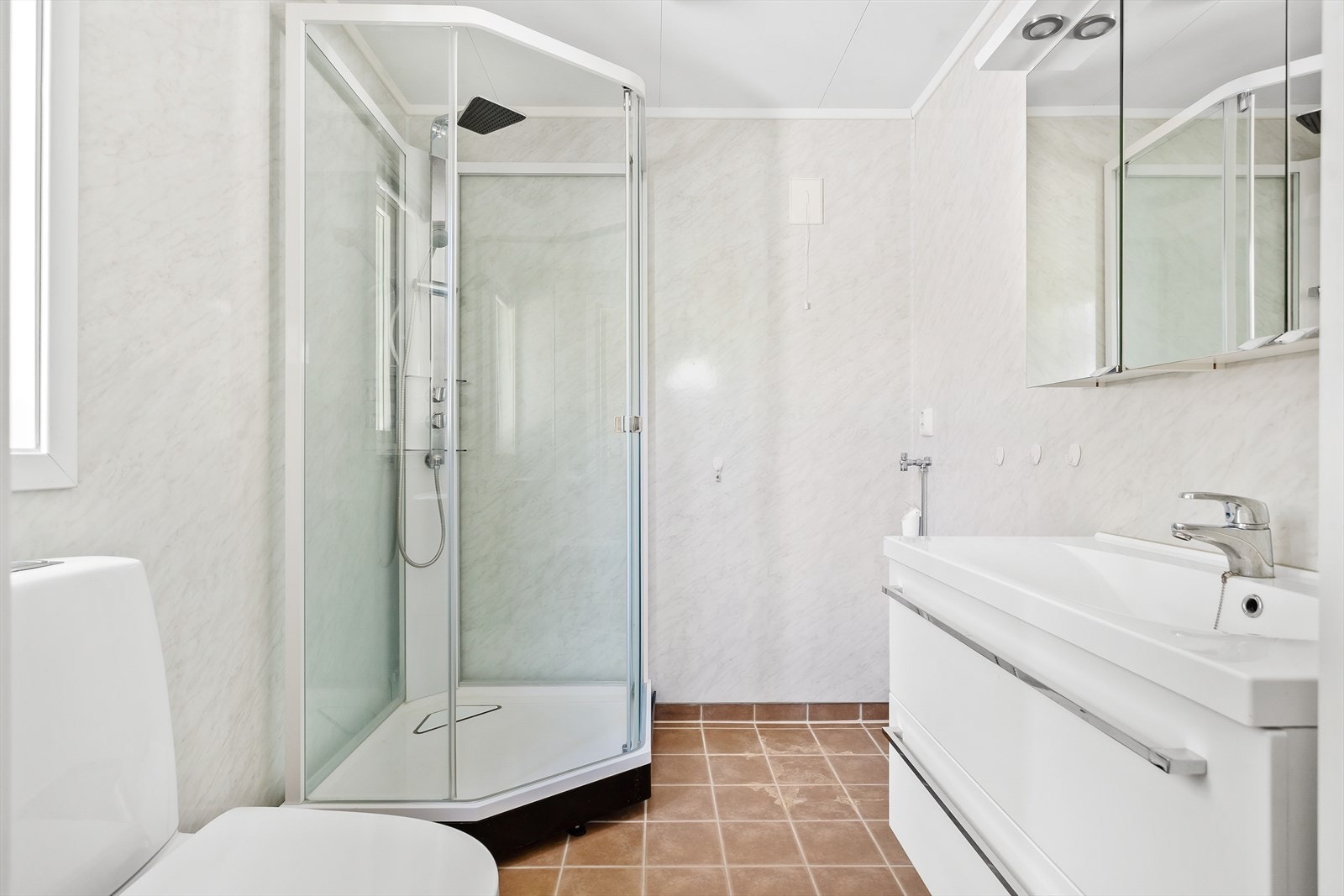 Badet er fra 2012 og har fliser på gulv og baderomsplater på vegger. Galleribilde