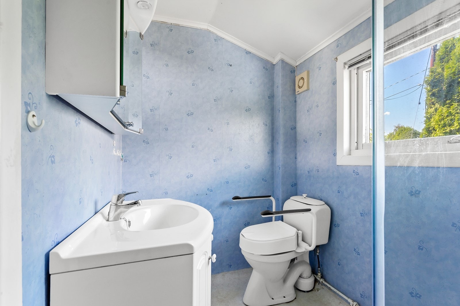 Rommet er utstyrt med baderomsinnredning med servant og ett-greps blandebatteri, speilskap, gulvmontert toalett og dusjkabinett. Rommet har naturlig avtrekk. Galleribilde