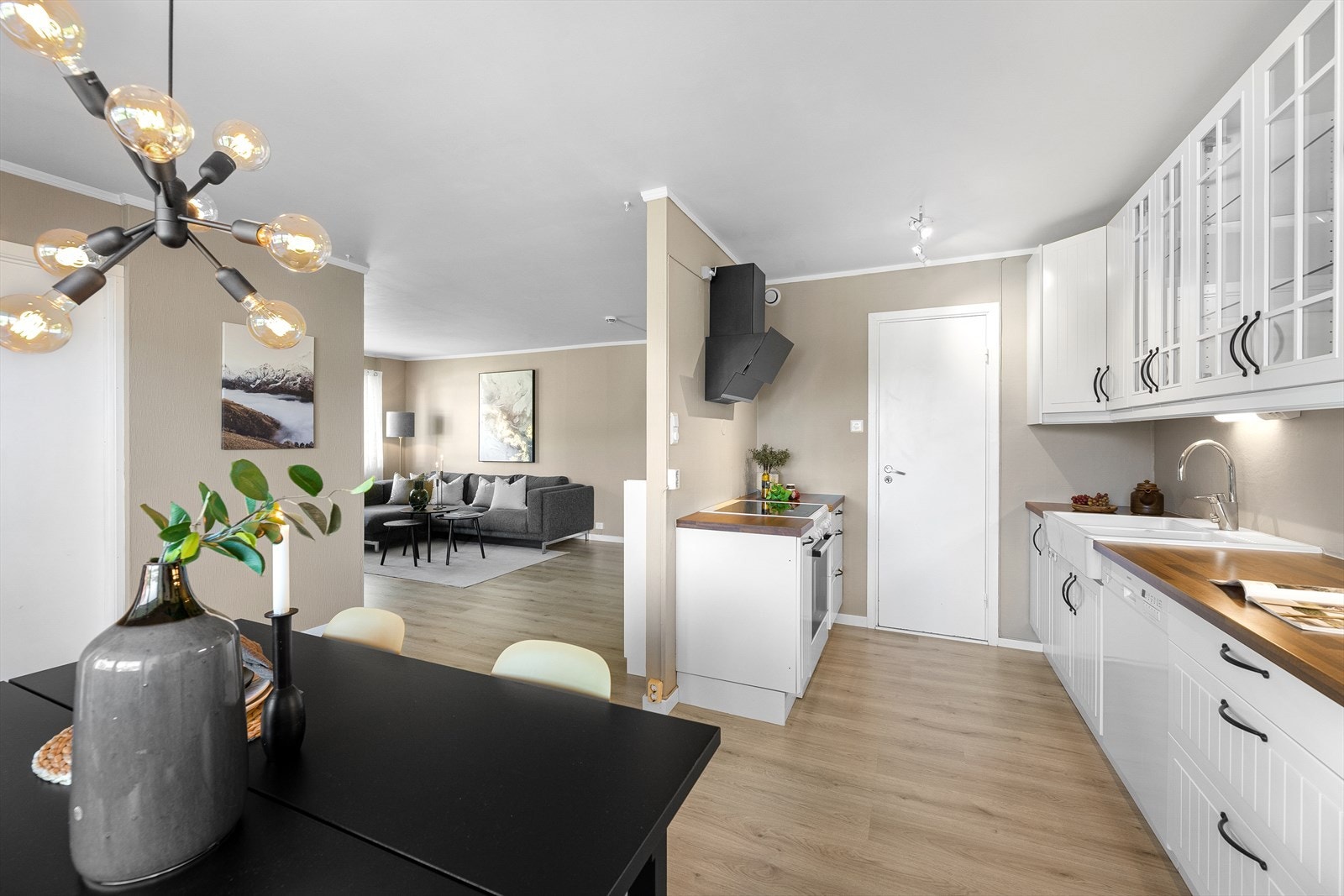 Hvit profilert kjøkkeninnredning, med god lagringsplass i skap og skuffer samt en romslig benk. Galleribilde