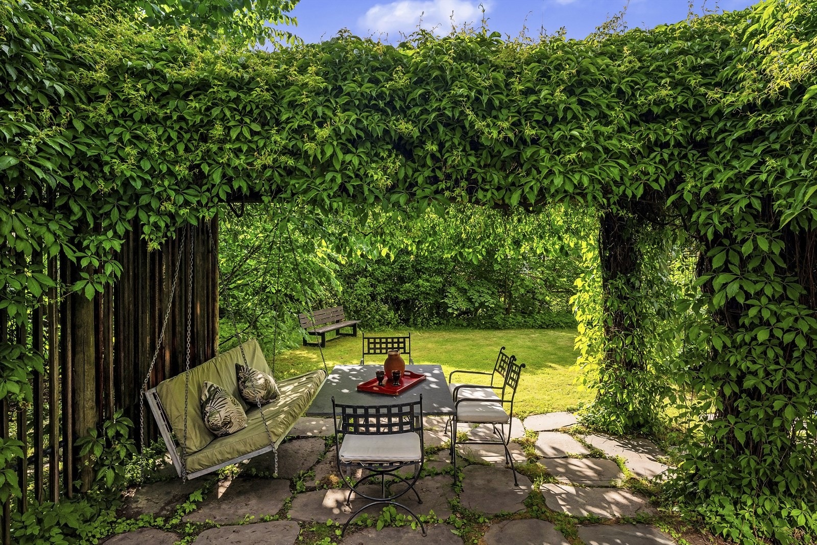 Idyllisk hagestue med pergola. Uteplassen er belagt med skiferheller. Galleribilde