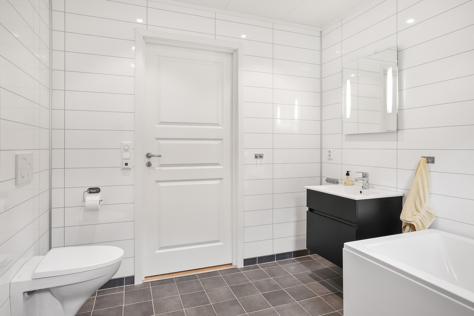 I 1. etasje er det et bad/ vaskerom med lyse baderomsplater på veggene og flislagt gulv med gulvvarme. Galleribilde