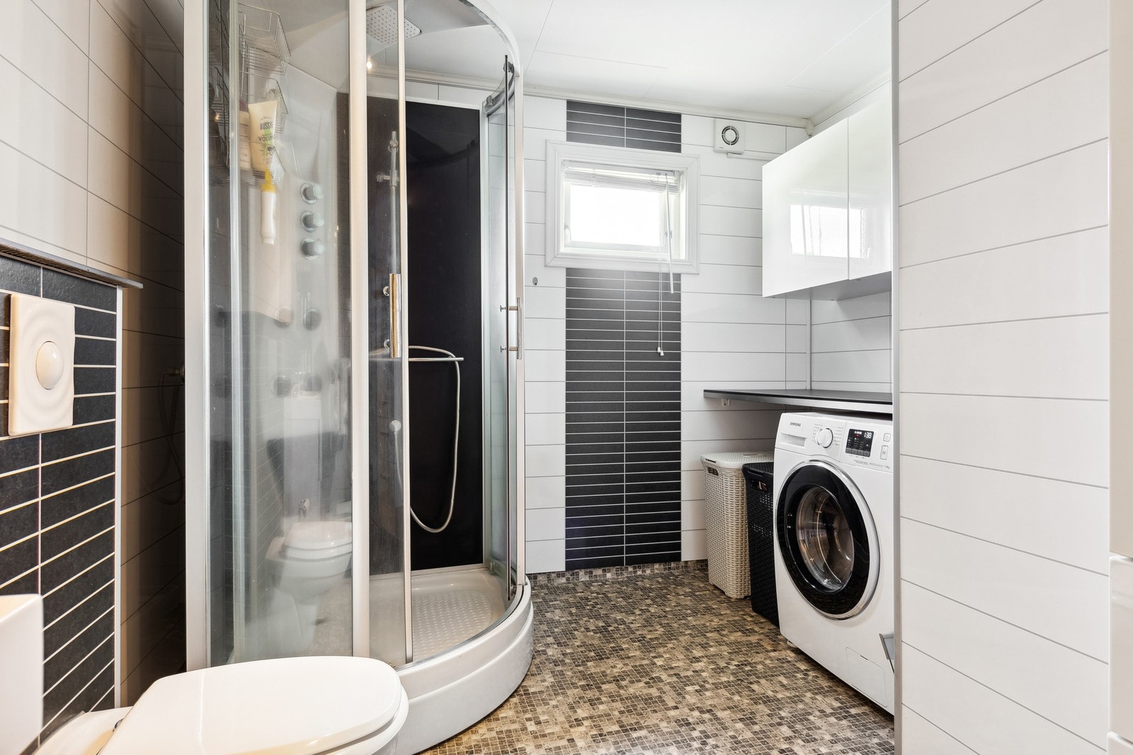 Badet har vegghengt toalett og opplegg for vaskemaskin. Galleribilde