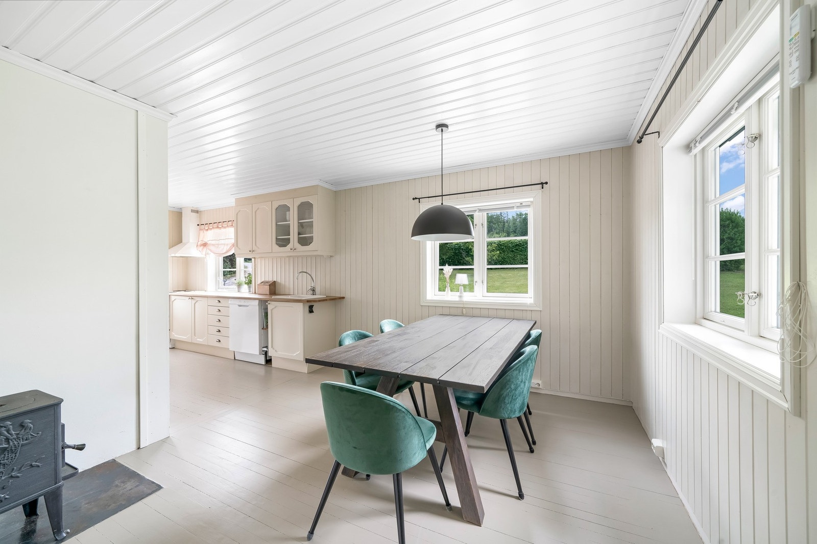 Spisestue er i åpen løsning med stuen og kjøkkenet. malt trepanel på vegger og himling, samt malt heltre gulv. Varmepumpe på vegg. Galleribilde