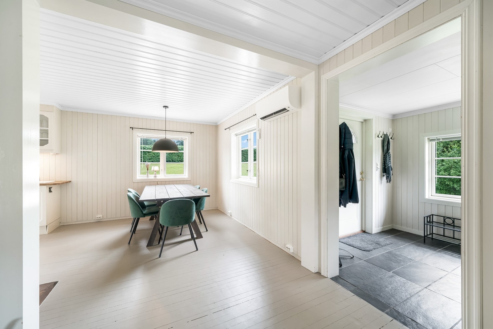 Innenfor inngangsdøra finner vi en stor flislagt gang, som videre leder inn i spisestue, kjøkken og stue med åpen løsning. Galleribilde