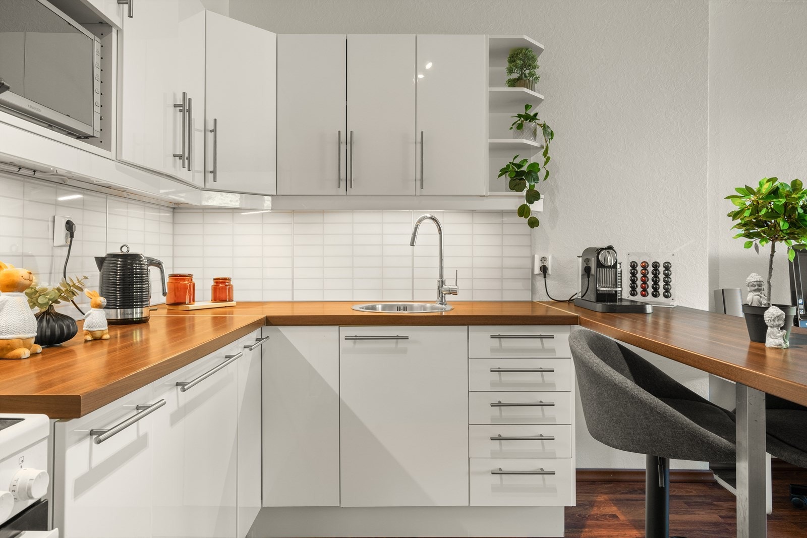 Kjøkkenet består av lys kjøkkeninnredning med slette fronter, laminat benkeplate og over benkeplaten er det benyttet kitchenboard. Galleribilde