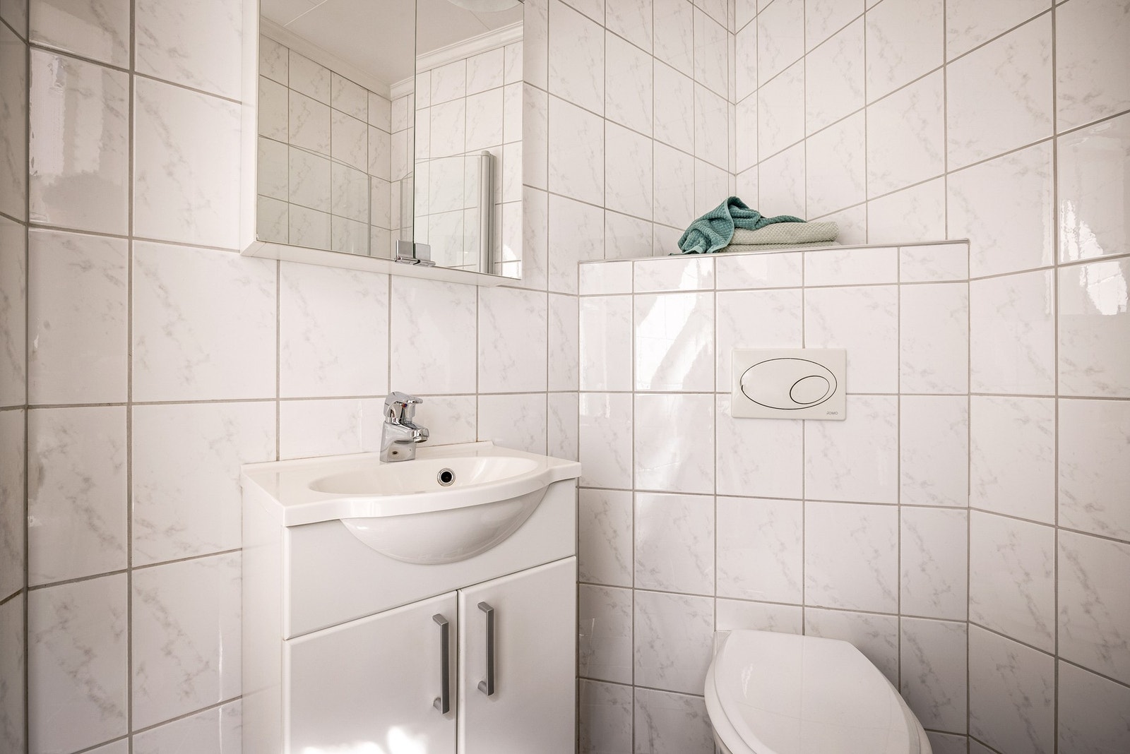 Fliser på gulv og vegger. Baderomsmøbel med servant og speilskap. Opplegg for vaskemaskin på eget vaskerom,like bak leiligheten Galleribilde
