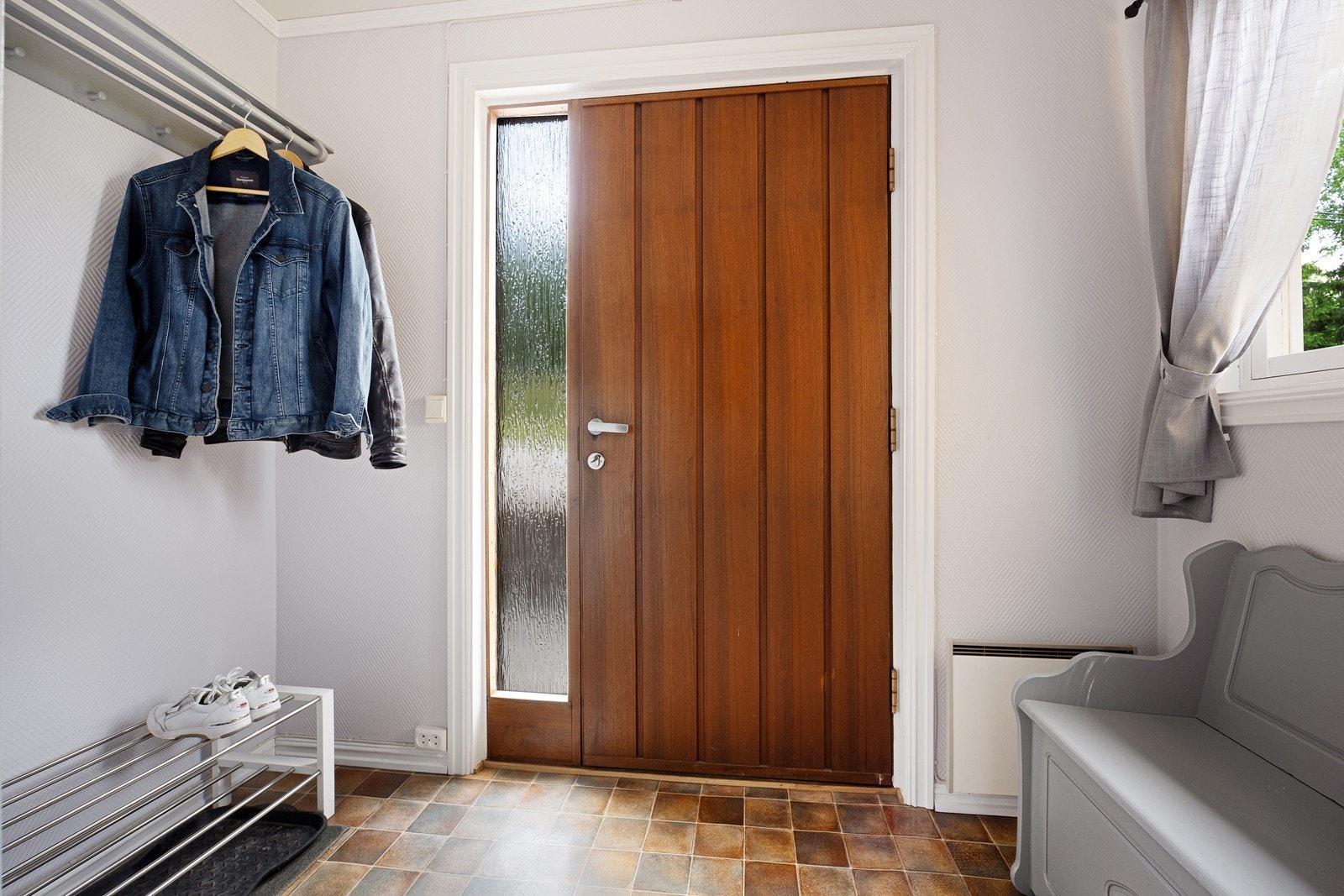 Boligen har inngang til et vindfang med hattehylle og plass til garderobeskap, kommode eller lignende. Galleribilde