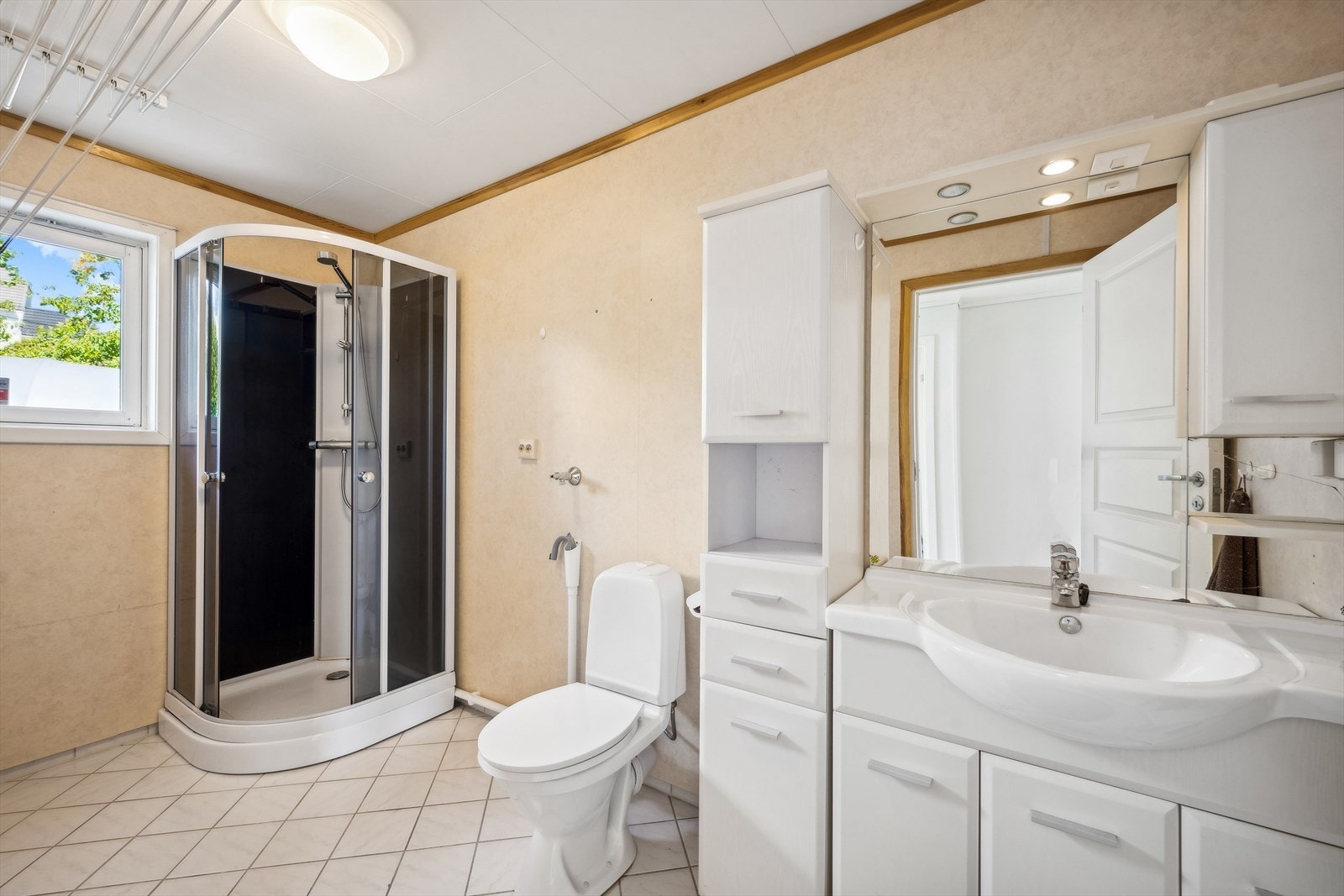 Badet i første etasje er innredet med WC, servant med oppbevaringsplass og dusjkabinett Galleribilde