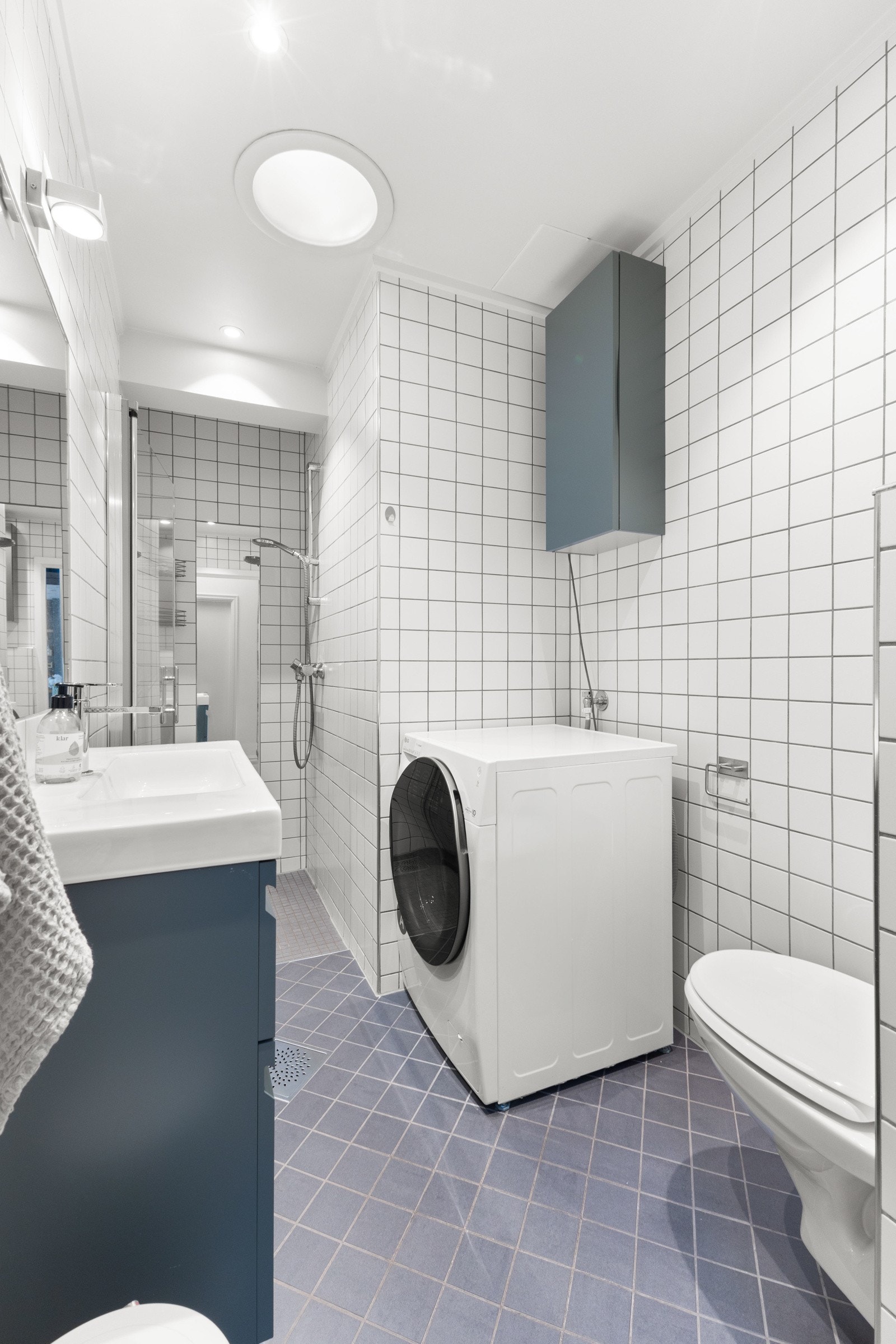 Pent flislagt baderom fra 2007 med downlights i himling og opplegg for vaskemaskin Galleribilde