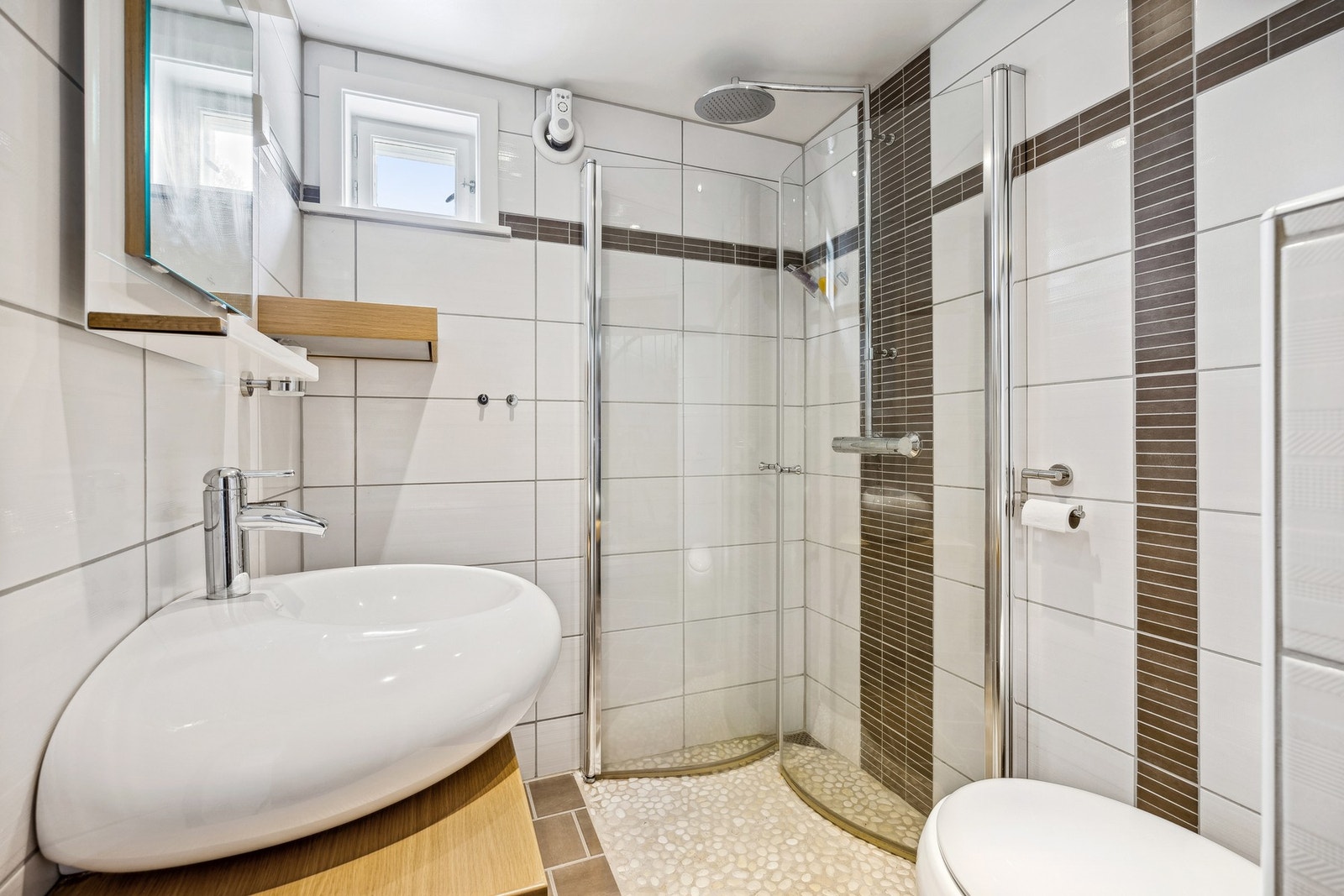 Lekkert flislagt bad (2009) i underetasjen med rullestein i dusjsonen samt vannbåren varme Galleribilde