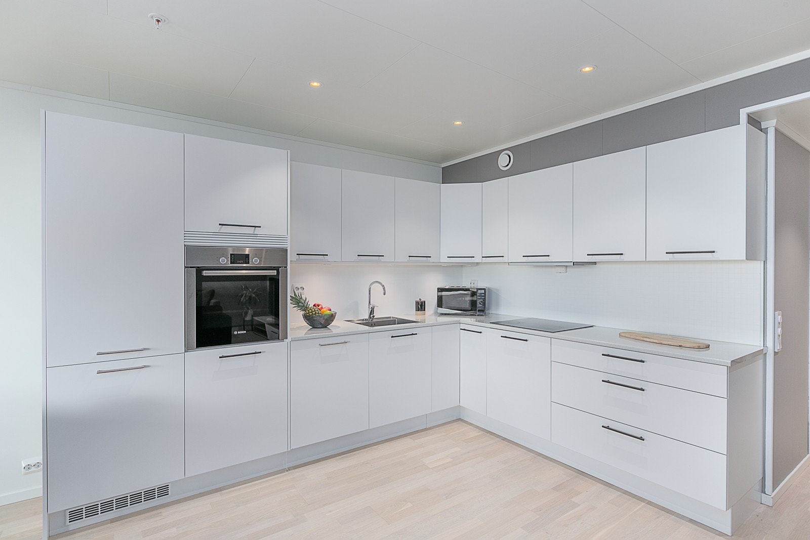 Pent og tidsriktig kjøkken med mye oppbevaringsplass og integrerte hvitevarer. Galleribilde