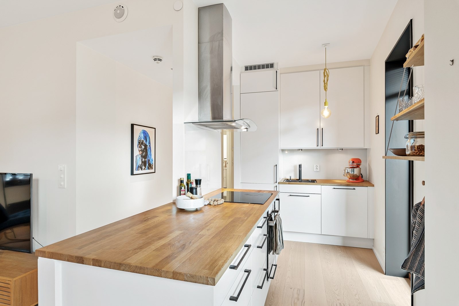 Kjøkkenet er innredet med hvite fronter, benkeplate i heltre eik med nedfelt oppvaskkum og induksjon platetopp. Galleribilde