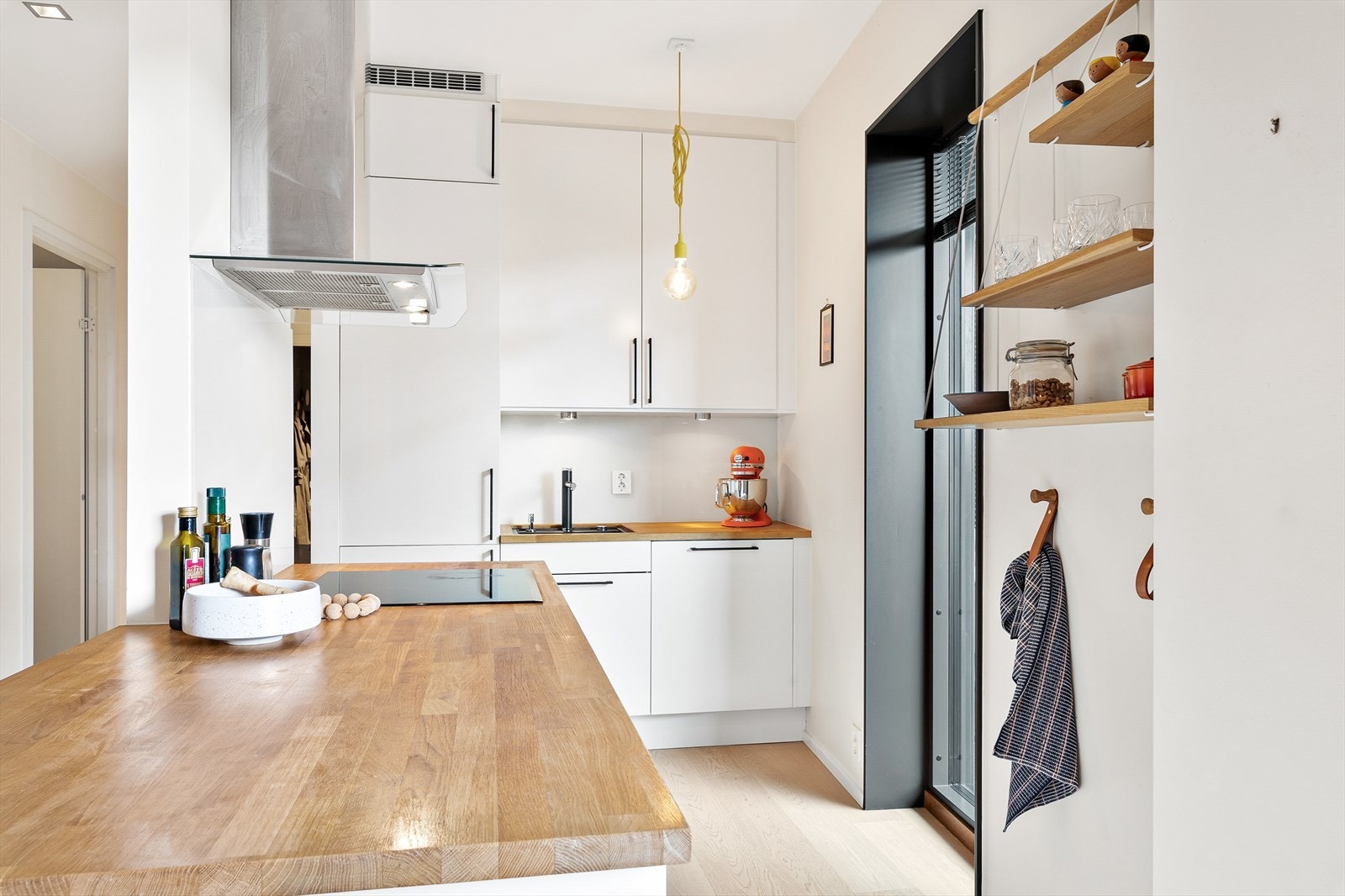 Kjøkkenet er utstyrt med integrerte hvitevarer som platetopp, komfyr, oppvaskmaskin og kombinert kjøle-/fryseskap Galleribilde