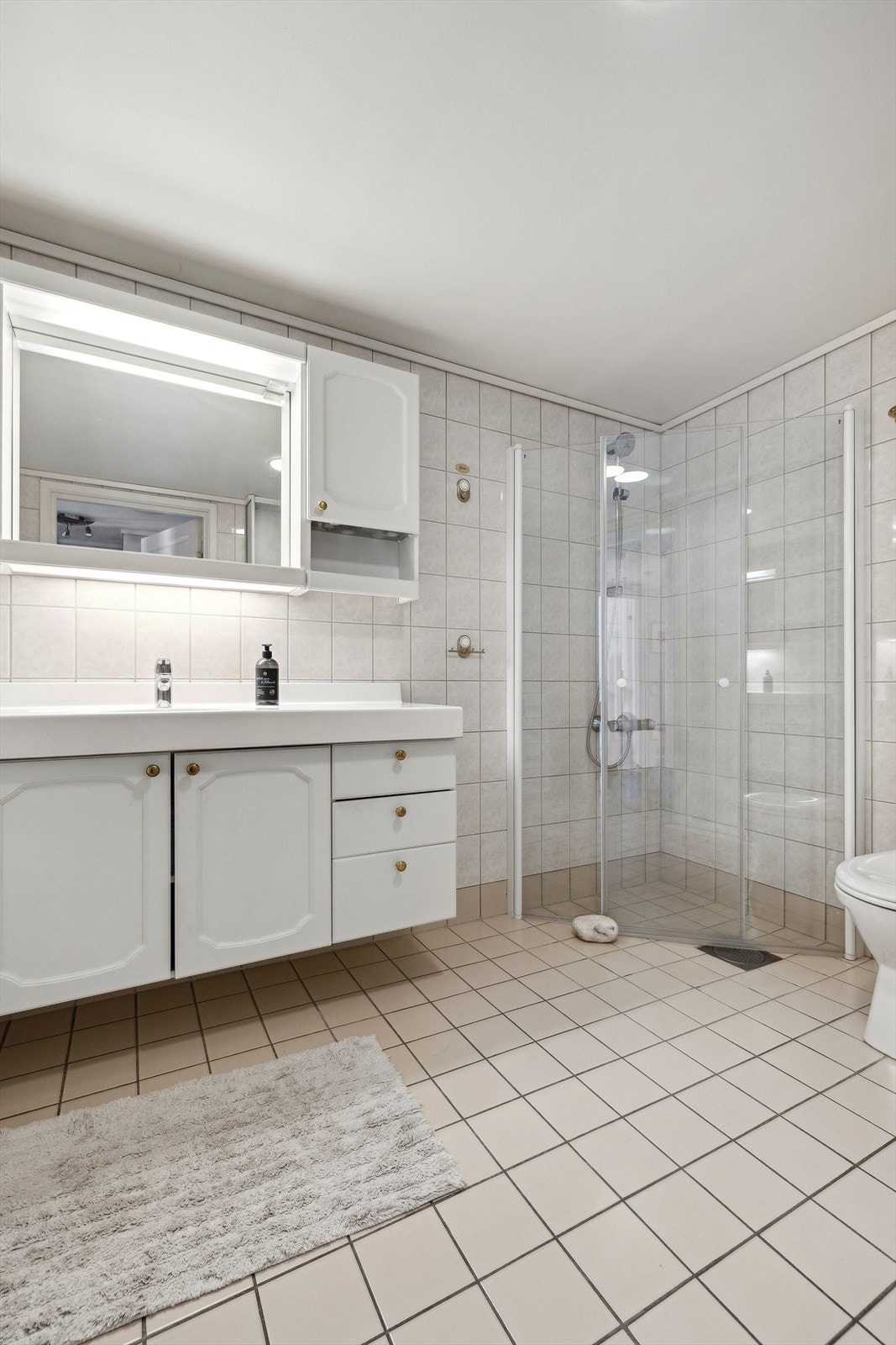 Stort bad. Badet er flislagt og har innredning og overflater fra byggeår Galleribilde