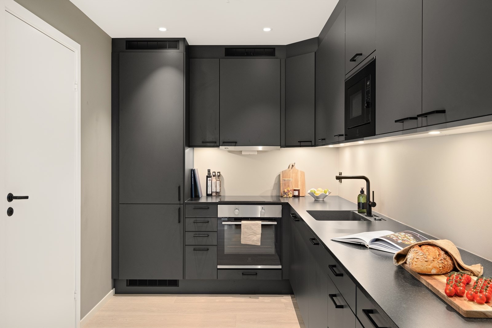 Kjøkkeninnredningen er i en lekker mørk utførelse, og består av glatte fronter og laminat benkeplate. Galleribilde