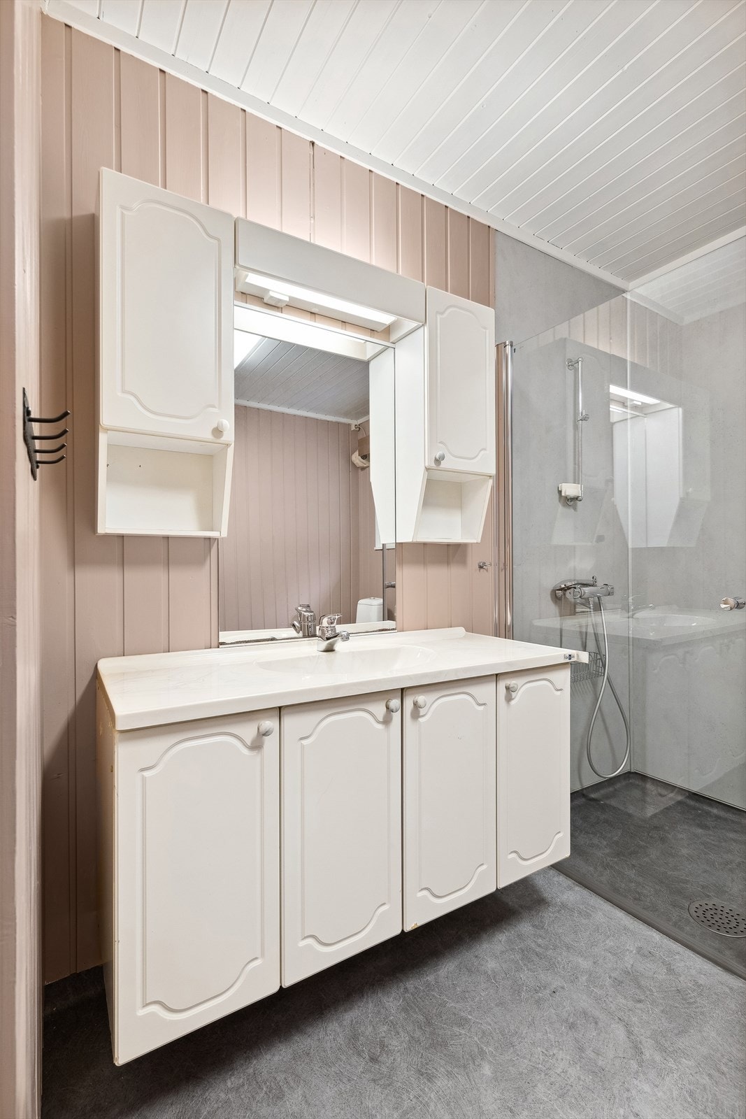 Badet har romslig innredning, dusjvegger, gulvmontert toalett og bidé, samt opplegg for vaskemaskin Galleribilde
